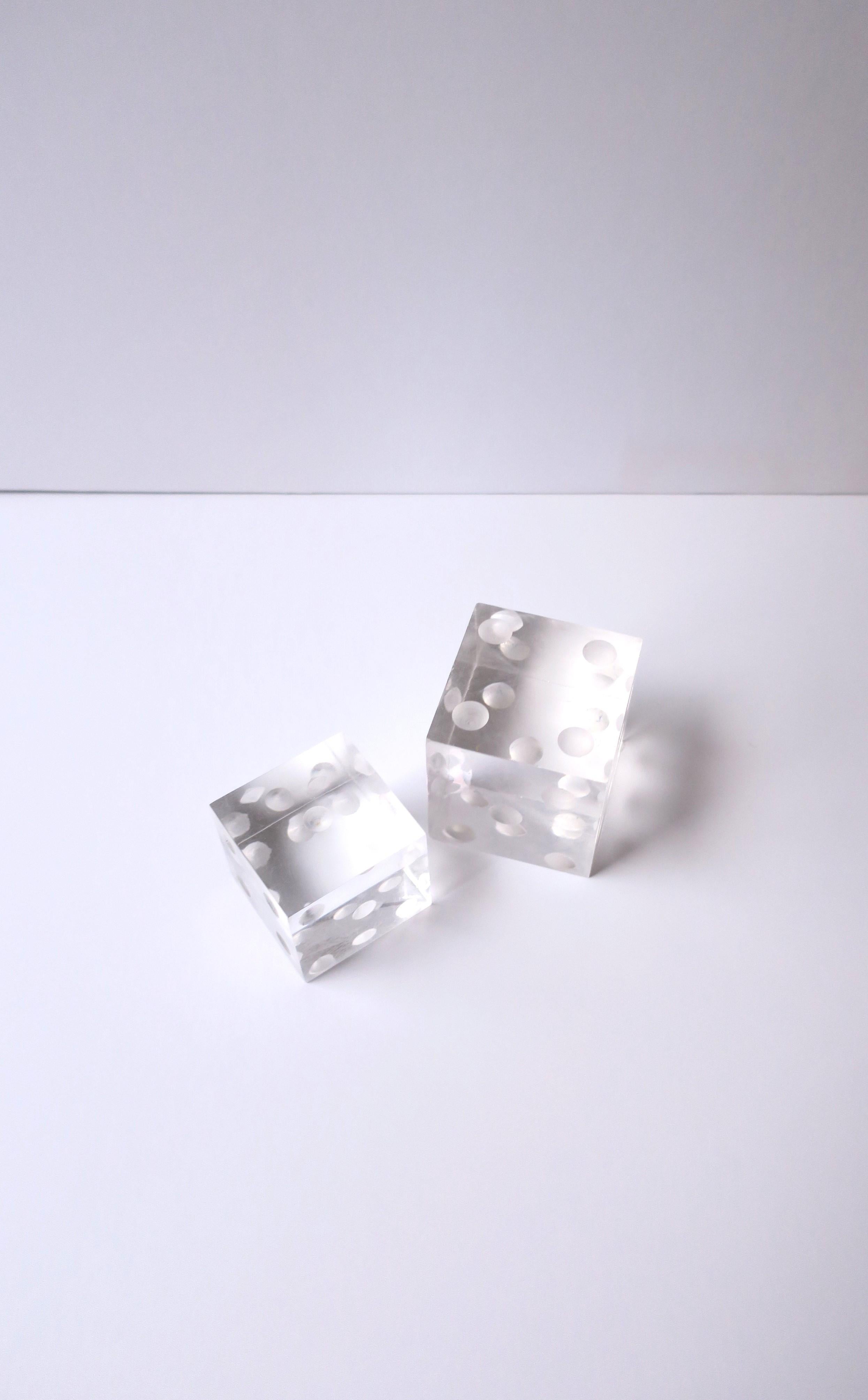 A pair/set of Lucite dice decorative objects, in the Modern style, circa late-20th century. A great set for a desk, bookshelf, coffee/cocktail table, etc. 

Dimensions:
2.44