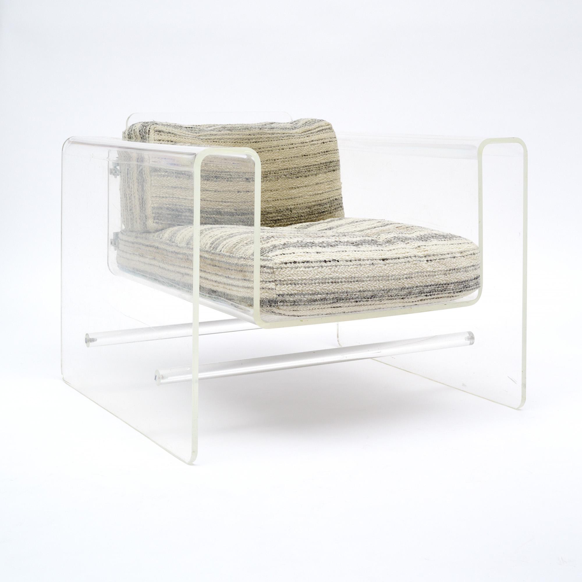 French armchair from the mid-century with a Lucite frame and original striped upholstery cushions. This piece is in very nice vintage condition with only minor surface wear consistent with age and use. The photos accurately depict the
