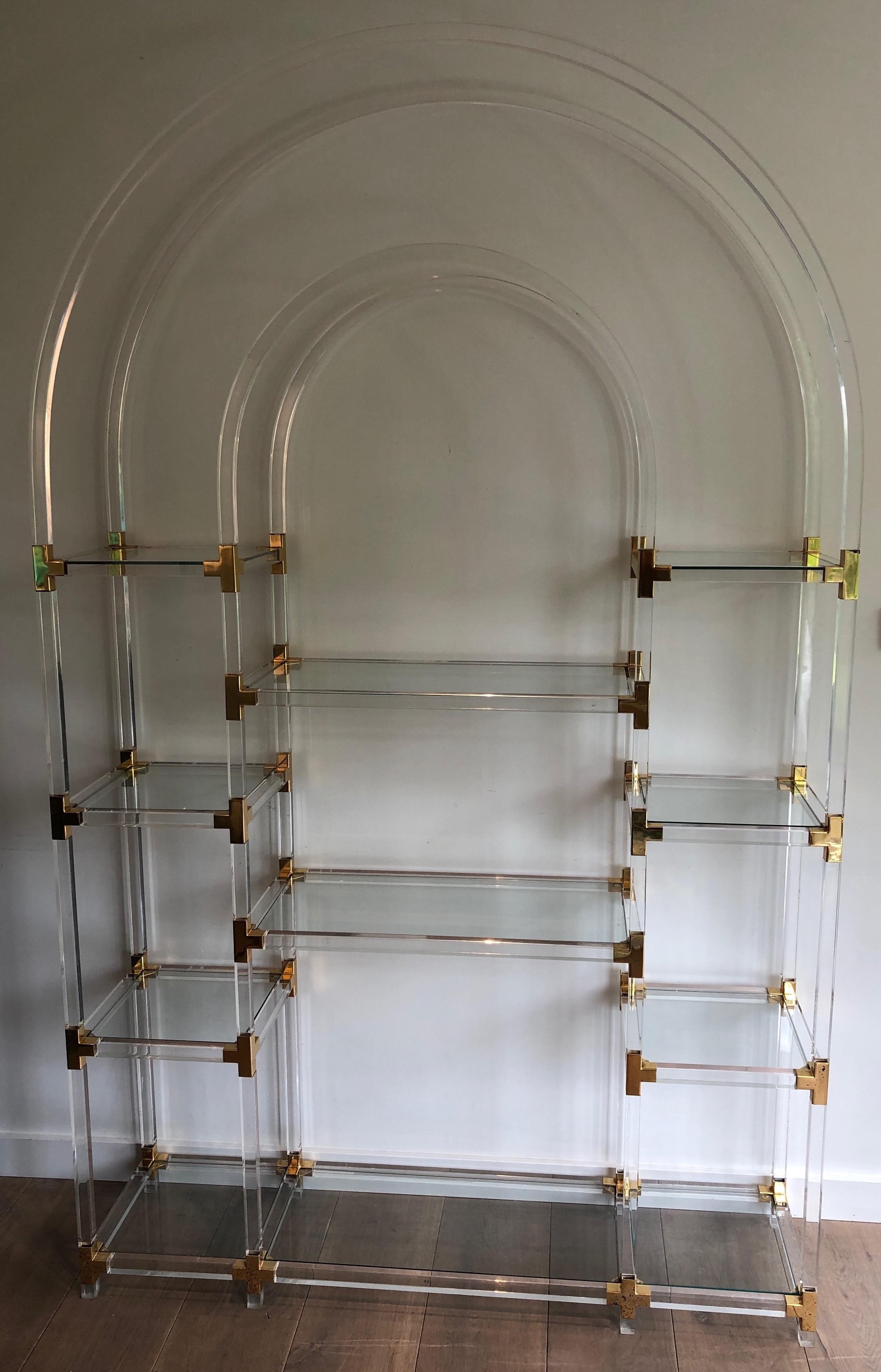 This very decorative shelves unit is made of lucite, gilded metal and glass. This is an American work by famous designer Charles Hollis Jones, circa 1970.