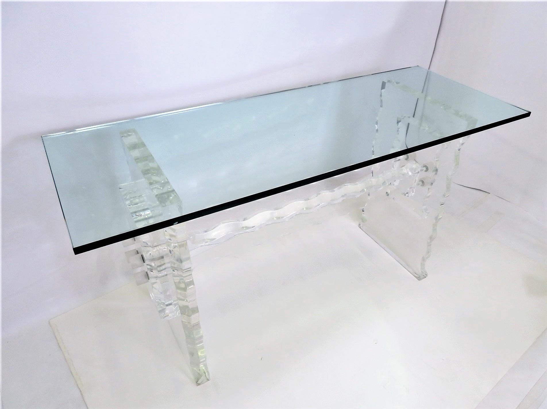 A glass topped Lucite based Console in the style and manner of Charles Hollis Jones and Leon Frost. Ruffle edged thick Lucite defines the base of this console or table, like an ice carving with a 3/4 inch thick glass rectangular top. Awesome curl