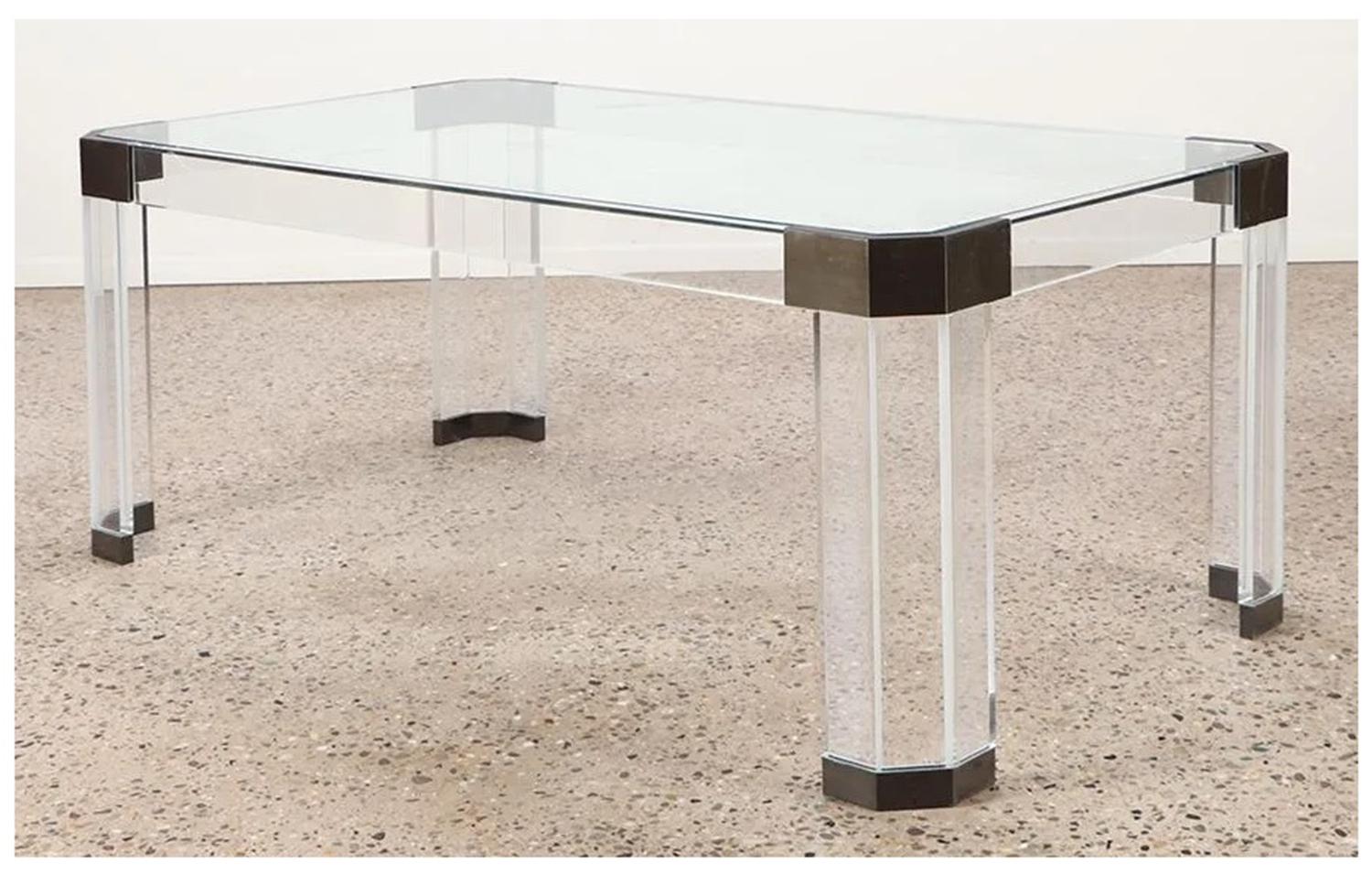Wir stellen den Esstisch aus Lucite, Glas und Messing von Charles Hollis Jones vor, ein atemberaubendes Möbelstück aus den USA der 1970er Jahre. Dieser rechteckige Tisch hat eine klare Glasplatte, die die exquisiten Akzente aus antikem Messing an