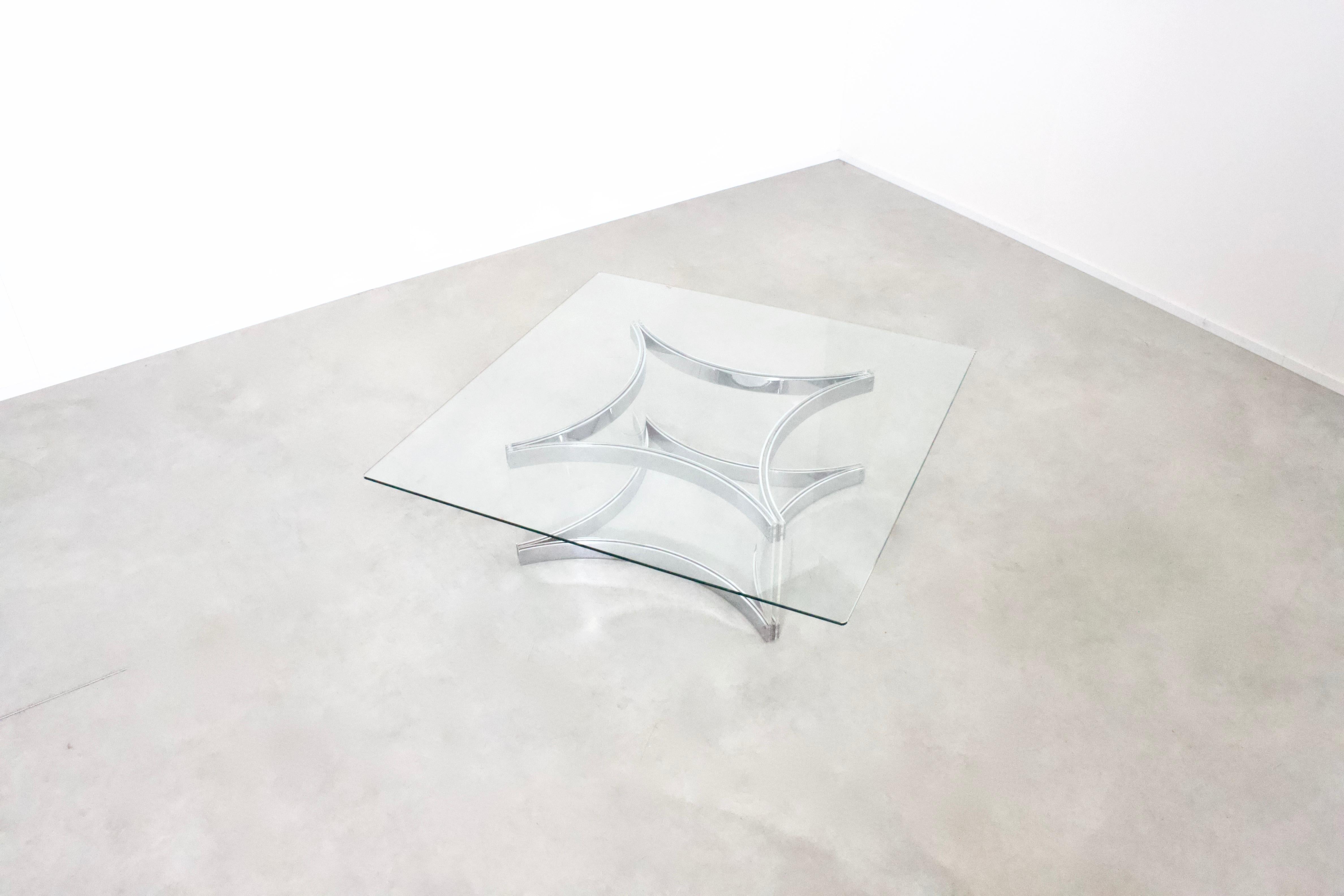 Superbe table basse d'Alessandro Albrizzi en très bon état.

La table a un plateau en verre carré.

La base est constituée de plaques de Lucite incurvées, serrées entre de lourds éléments métalliques chromés.

Les caractères gras de la signature
