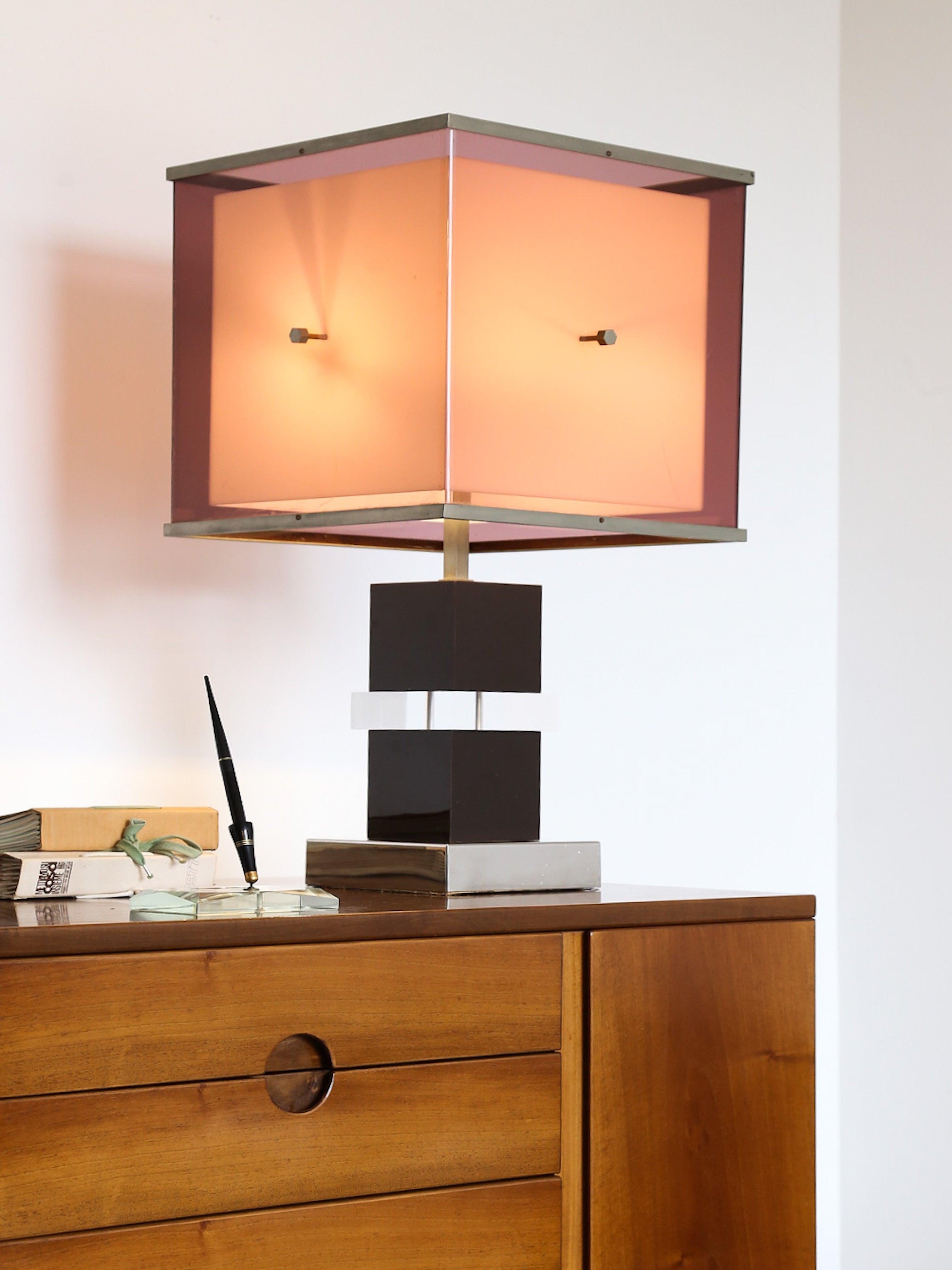 Crafted from high-quality materials, this lamp features a modernist design with two-tones of purple double Lucite shades with metal edges supported by black Lucite columns on square brass bases. The sleek and minimalist design exudes sophistication