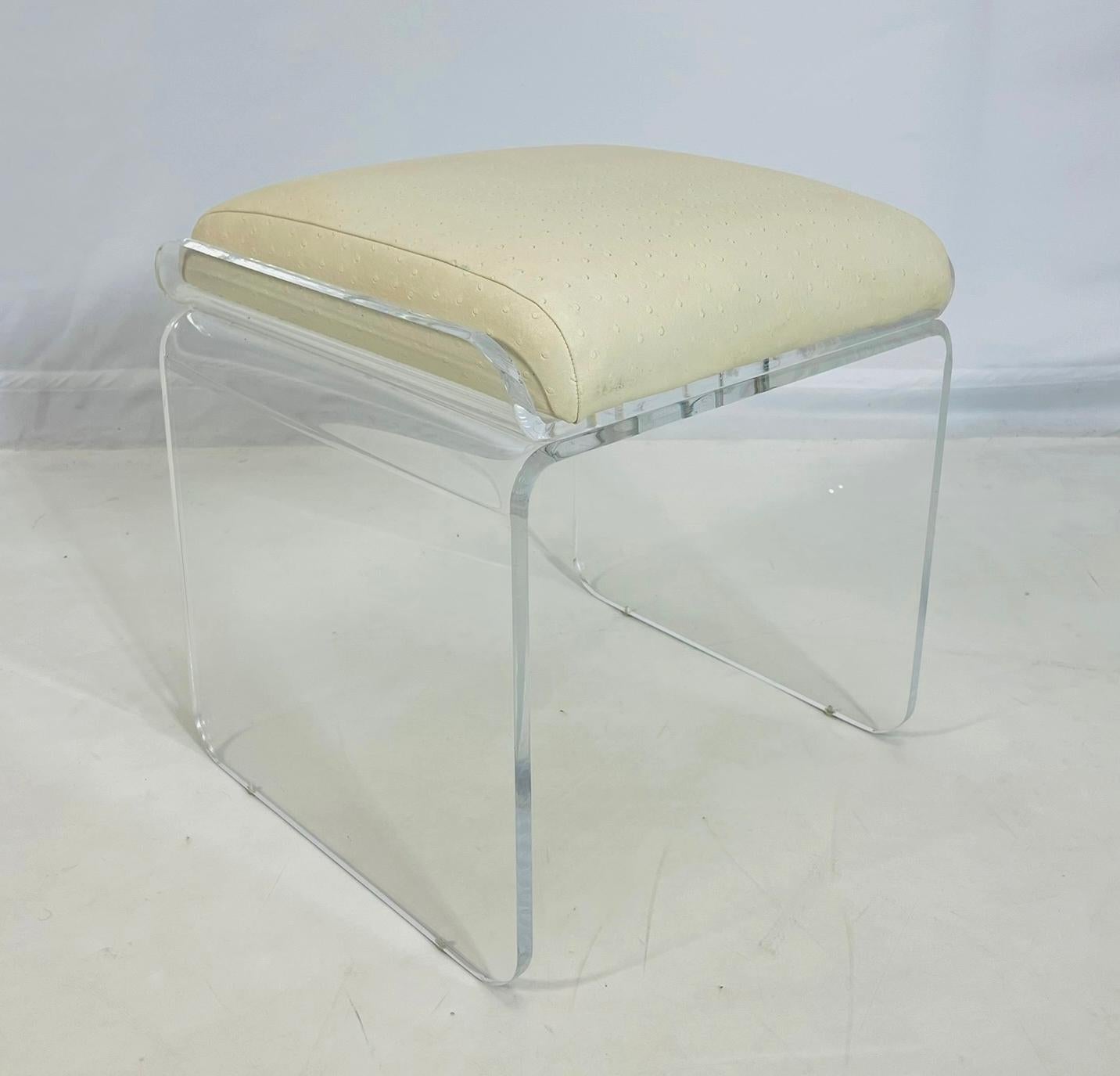 Vintage vanity swivel bench, entworfen und hergestellt in den Vereinigten Staaten in den 1960er Jahren von Charles Hollis Jones.

Die Bank ist aus Lucite gefertigt und mit einem cremefarbenen Leder mit Straußenmuster gepolstert.

Der Sitz ist mit