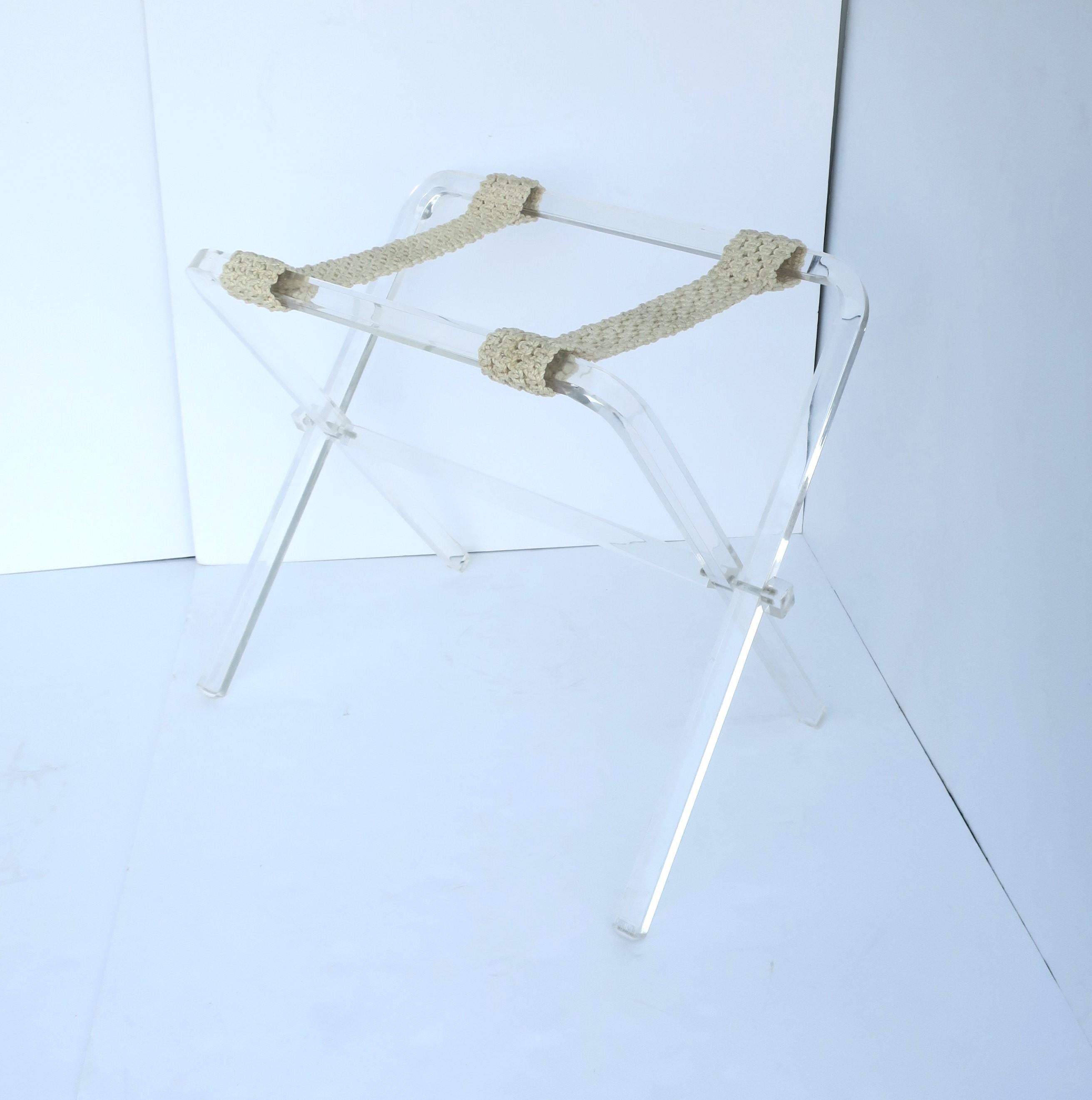 A lucite luggage rack with ivory straps in the Hollywood Regency style, circa late-20th century. Piece neatly folds up as shown in last image. 

Dimensions: 16.25