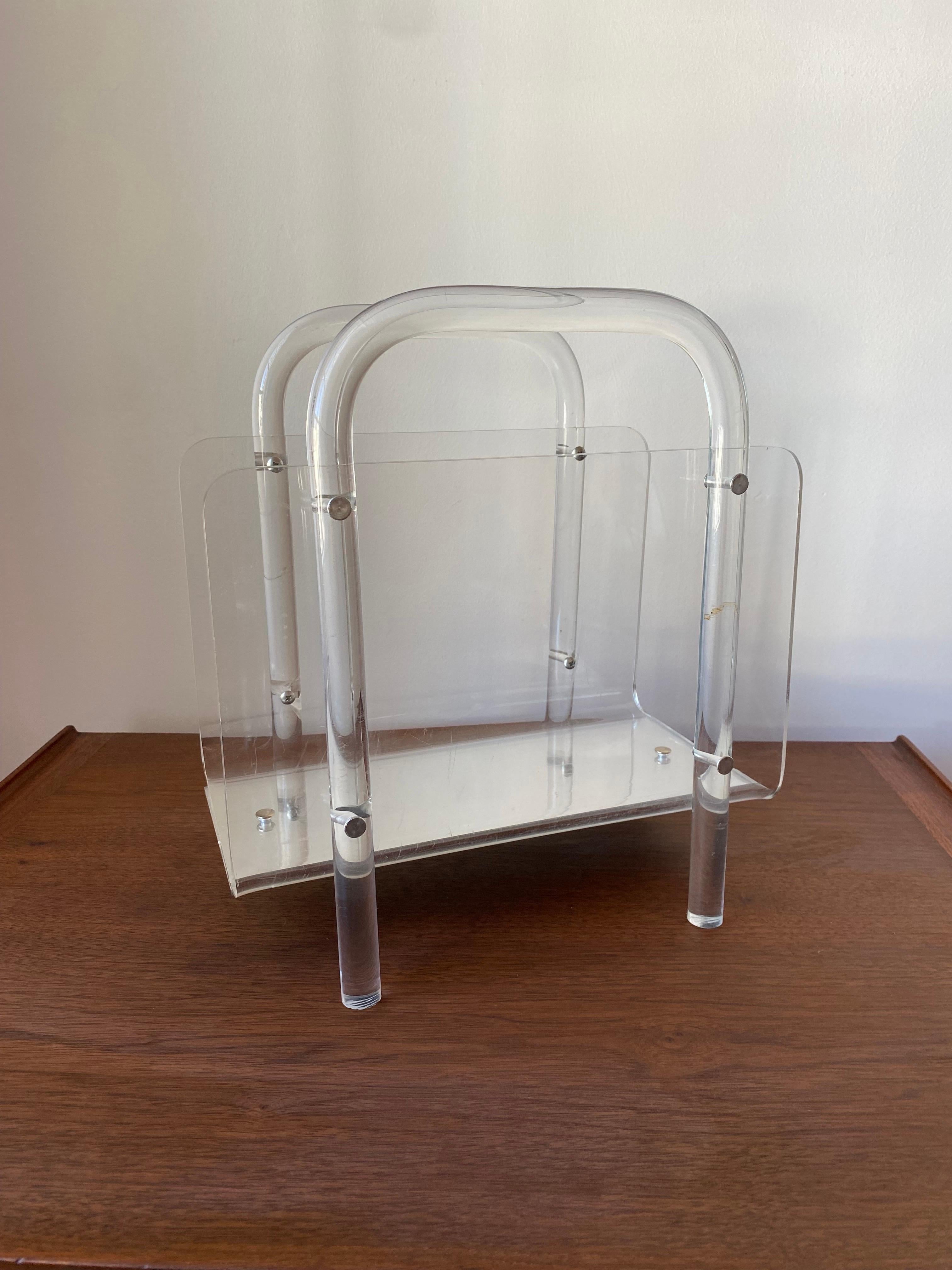 Bellissimo portariviste degli anni '60 circa.  Bellissima struttura in lucite che non richiede sforzi e che è minimale.  La base del supporto comprende uno specchio che esalta le caratteristiche minimaliste e spaziali di questo pezzo.  Fresco,