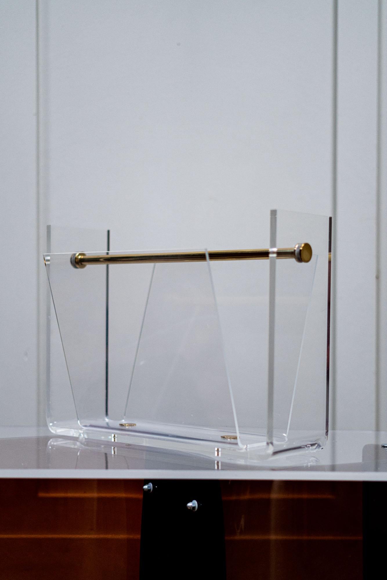 A 1970s Lucite magazine rack with brass handle and fixing plates.

Very good condition for age and use.

Possibly French.

Measures: Height 31cm
Length 43cm
Depth 24cm.