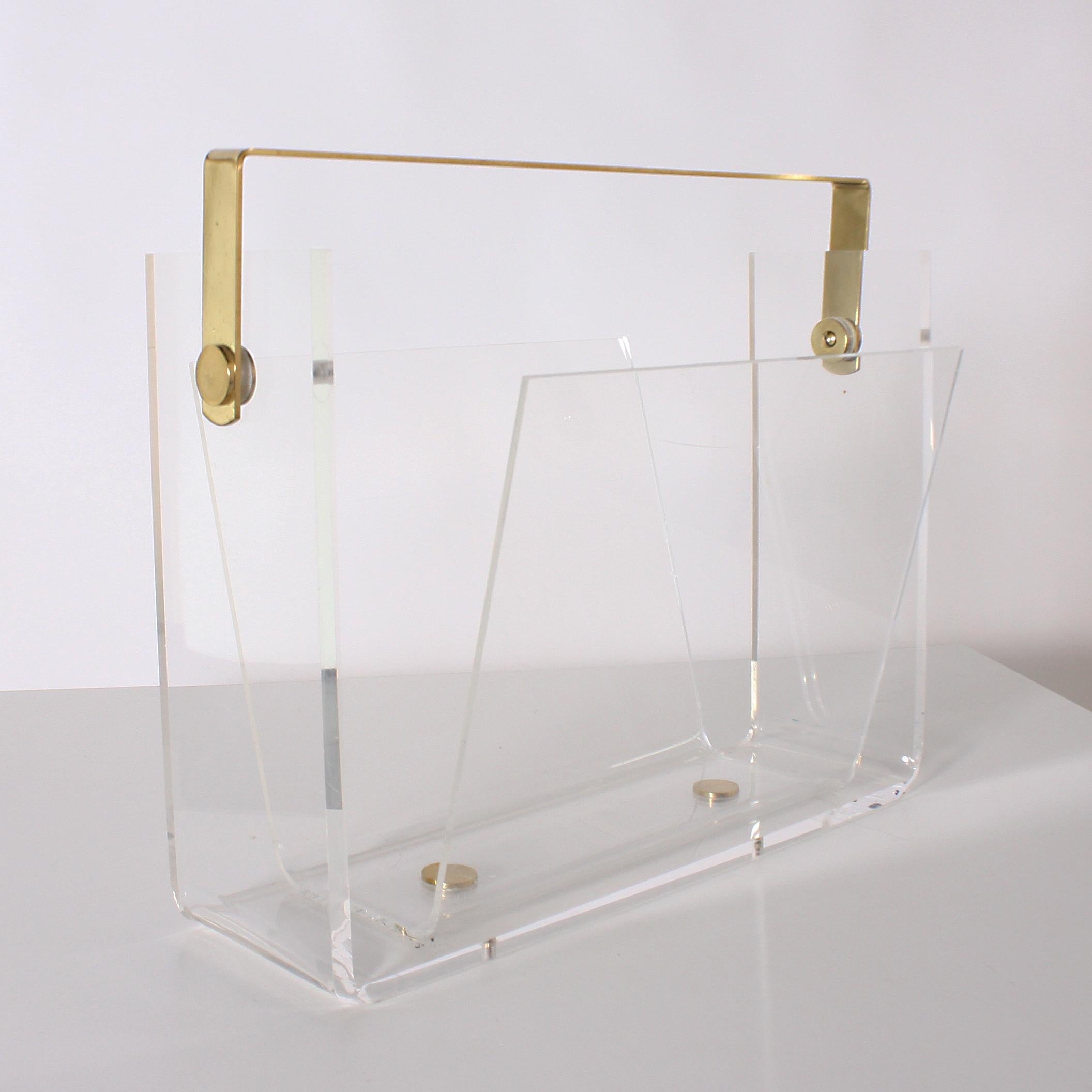 Lucite magazine rack with brass handle and detail, circa 1960.
 