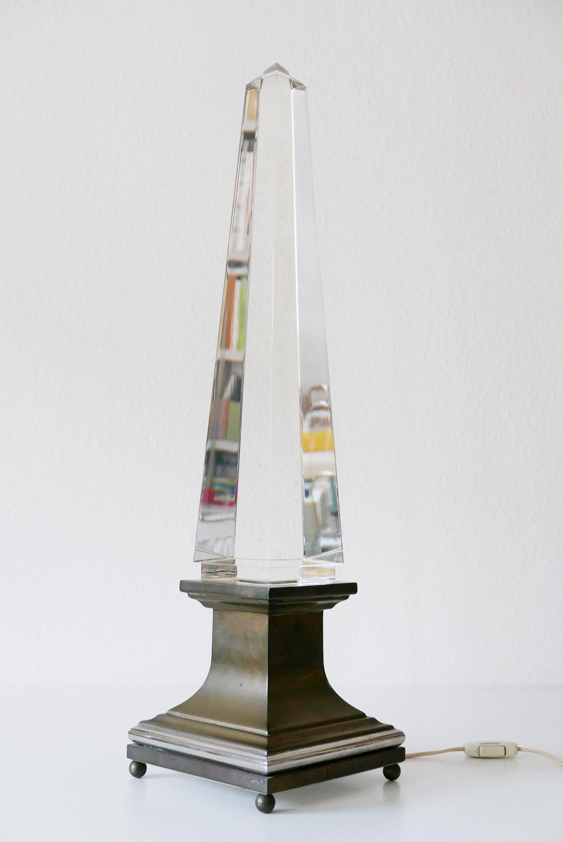 Monumental Mid-Century Modern Lucite table lamp in shape of an Obelisk. Designed by the Italian architect Sandro Petti for Maison Jansen, France, 1970s.

Executed in Lucite and brass. The lamp needs 2 x small fluorescent tubes, is with original