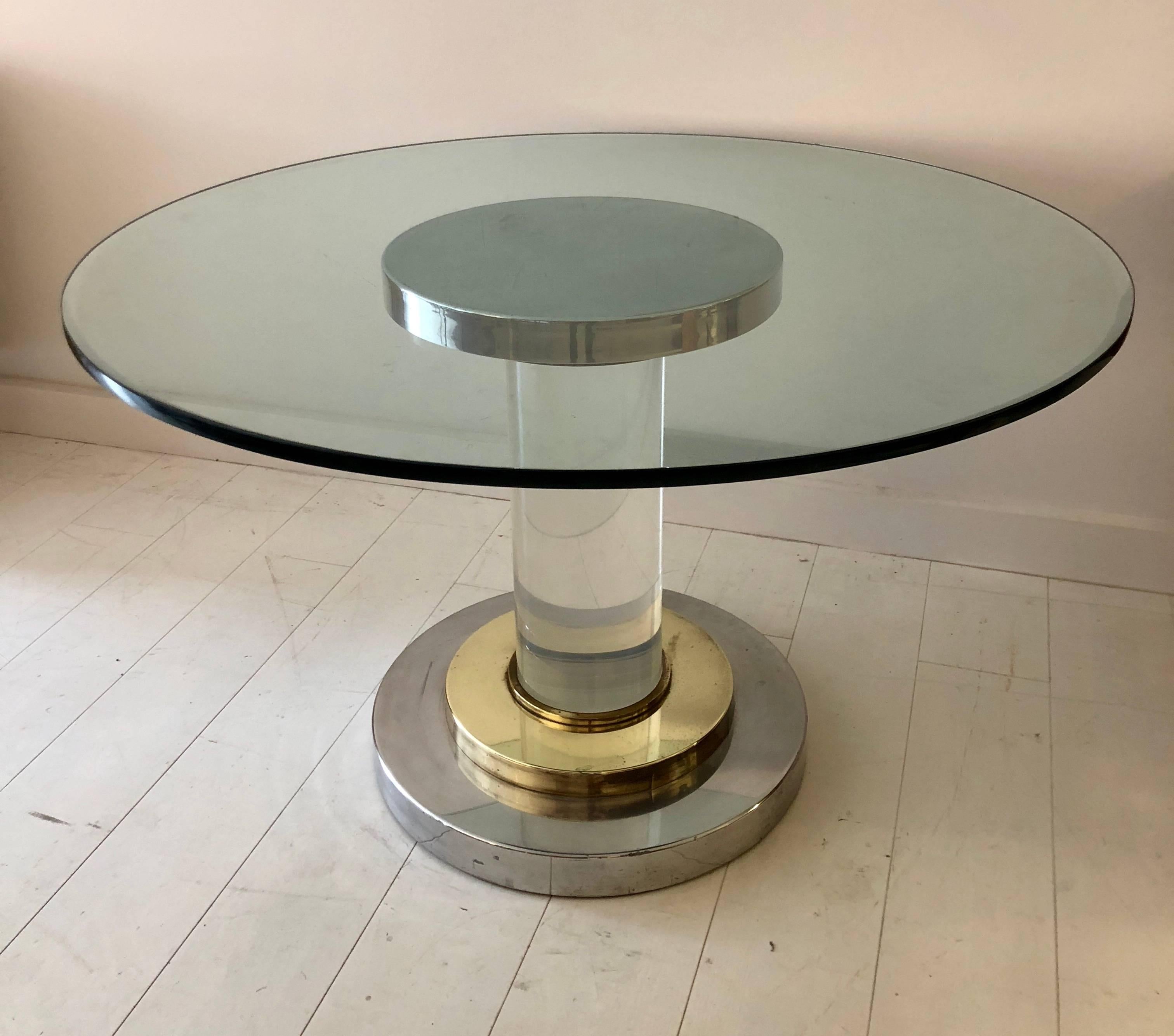 Center or dining table composed of a chic mix of polished brass, chromed steel and 8” D solid Lucite, with a 1” thick plate glass top, circa 1970.