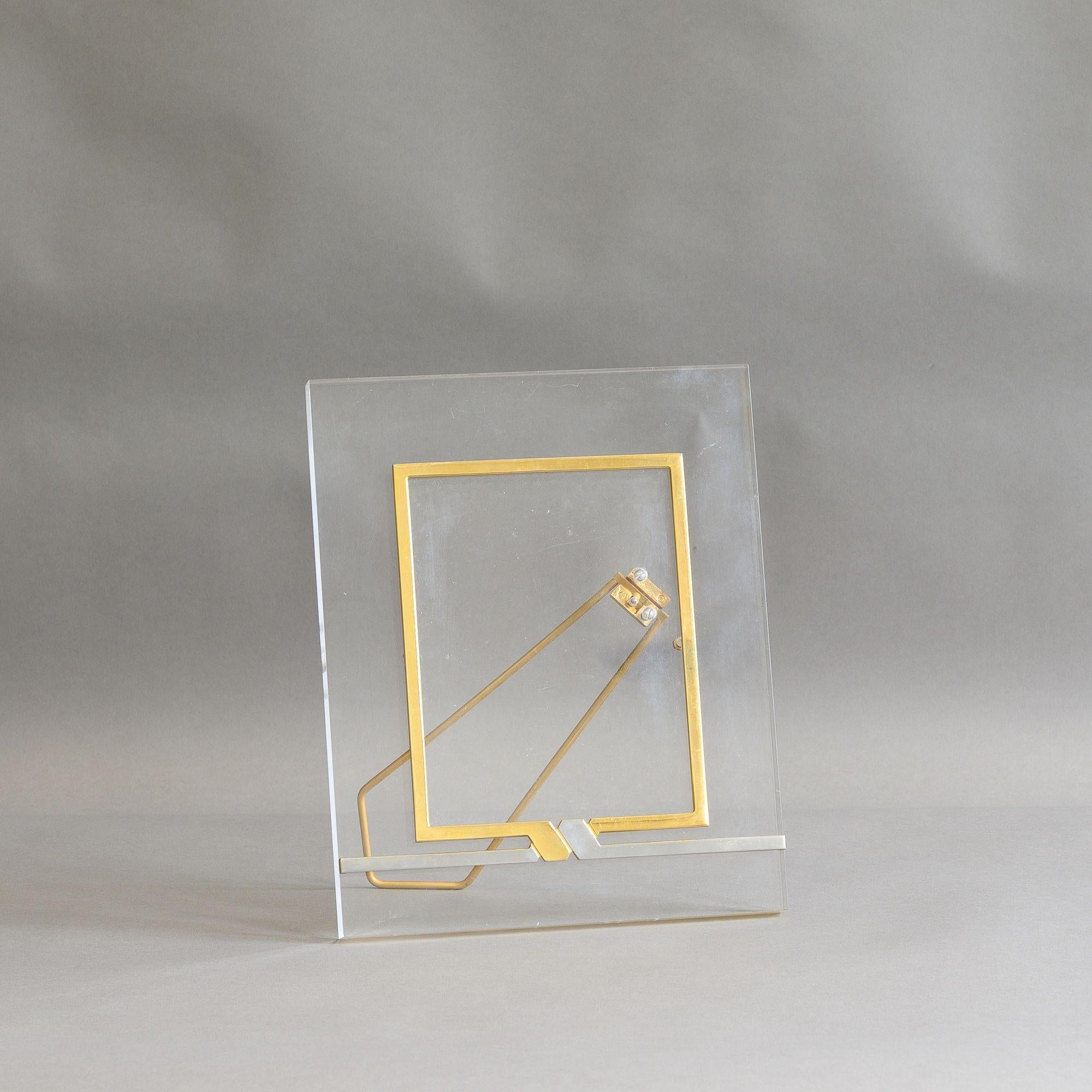 Cadre photo de style régence hollywoodienne du milieu du siècle en lucite et laiton. France vers 1970.
H 28cm x L 22cm x P 15cm