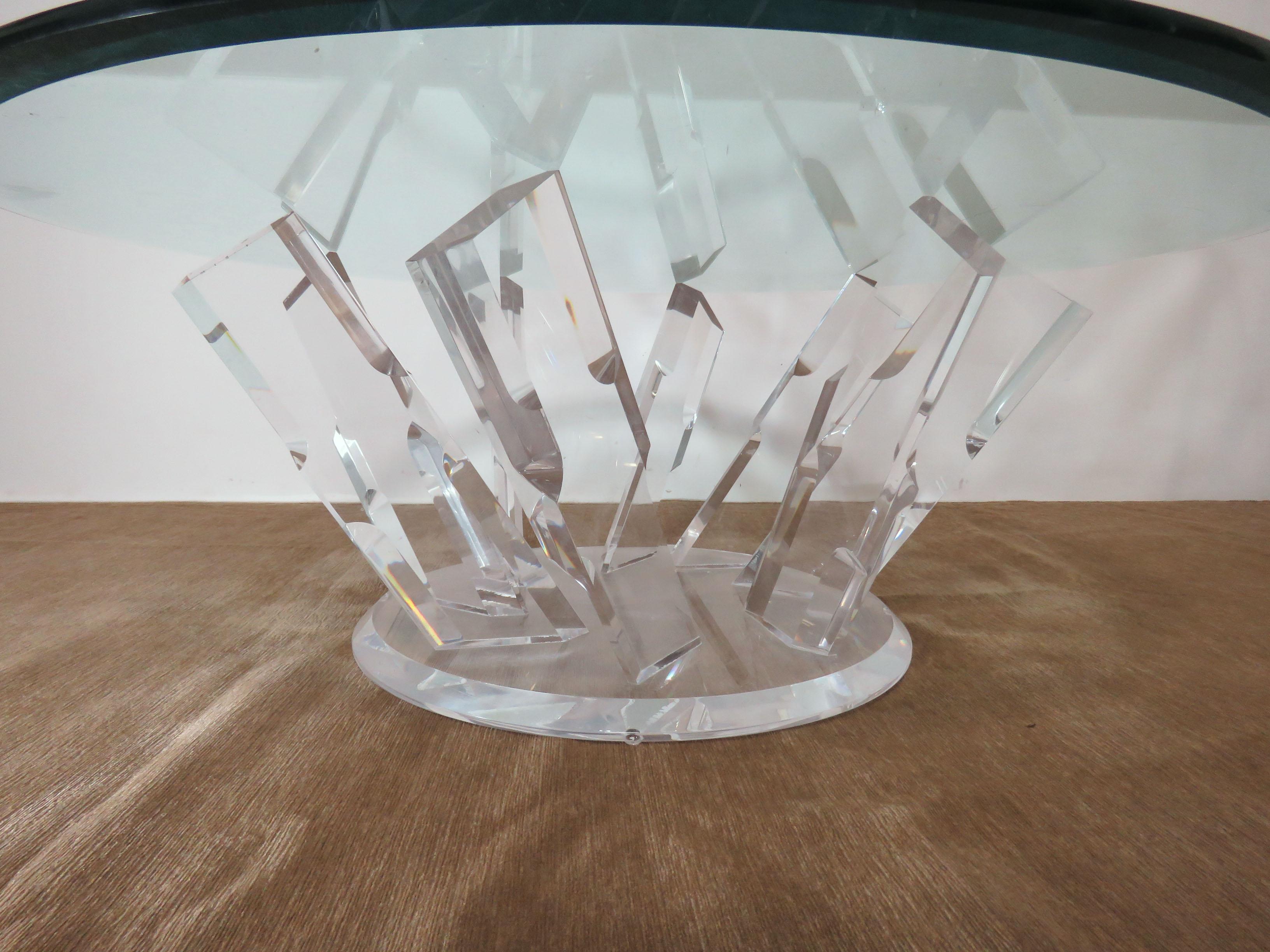 A radiant arm, pinwheel form cocktail table, circa 1980s, in carved Lucite acrylic and fitted with beveled 3/8