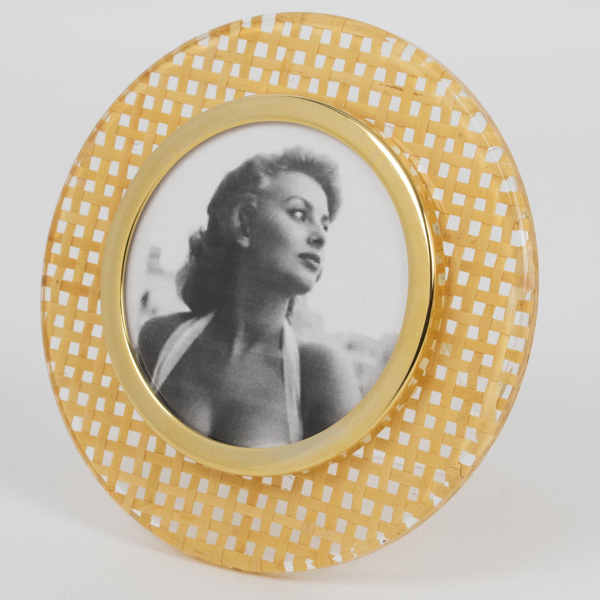 Questa splendida cornice decorativa è perfetta per un salotto o una vanità. Il portafoto ha una forma arrotondata con lucite trasparente e canna di rattan o vimini. Il rattan è incastonato nel materiale Lucite. Il quadro è circondato da una cornice