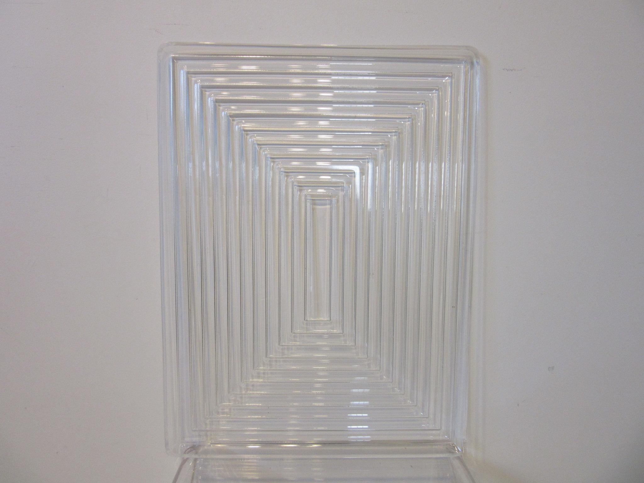 A large well crafted Lucite serving tray with raised horizontal and vertical line designs getting tighter towards the center giving the piece a sophisticated look in the manner of Eliel Saarinen and Art Deco.
