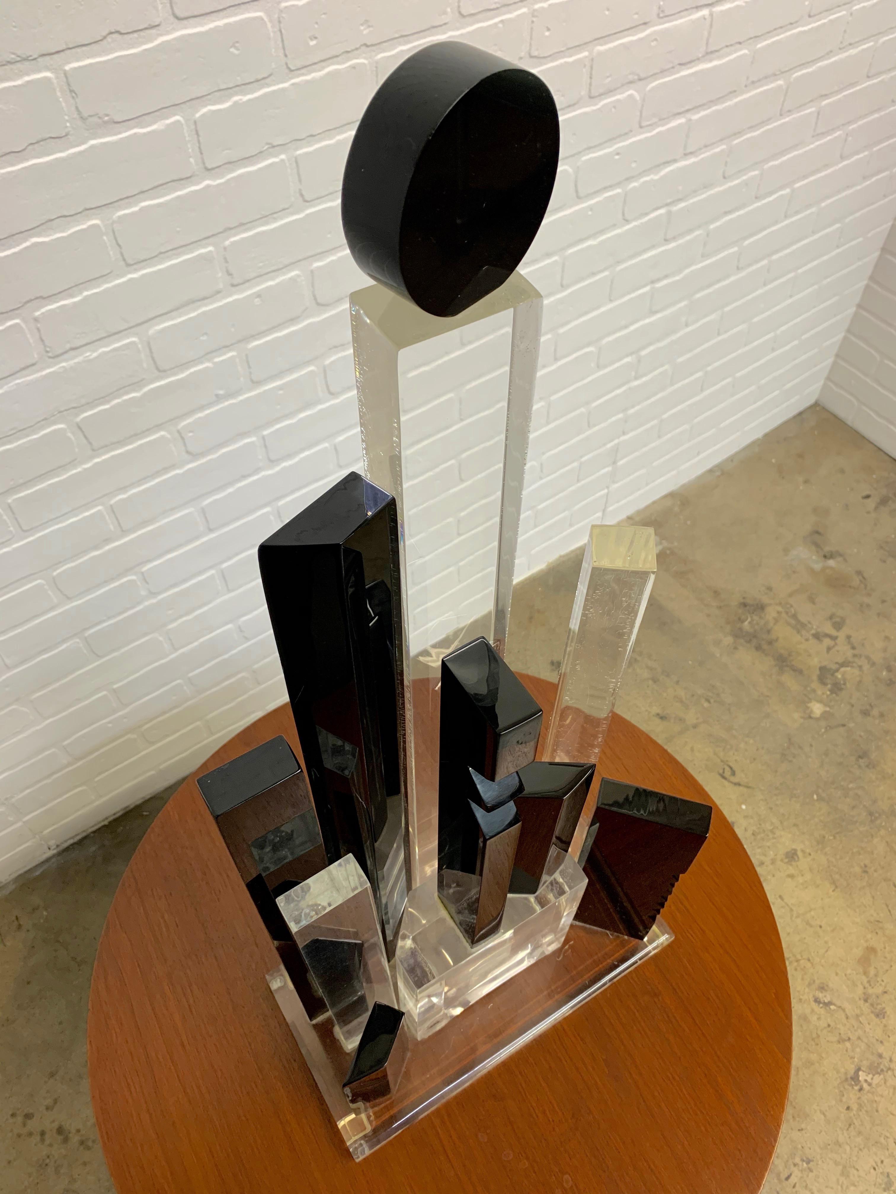 Black and clear geometric shapes that form a Postmodern cityscape sculpture.