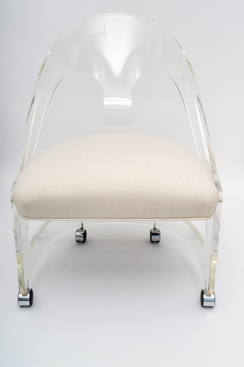 This stylish Hollywood Regency style Lucite spoon back chair will make the perfect perch for your dressing table or perhaps in your dressing room.

The piece has been professionally upholstered in a woven silk fabric (September 2019).
