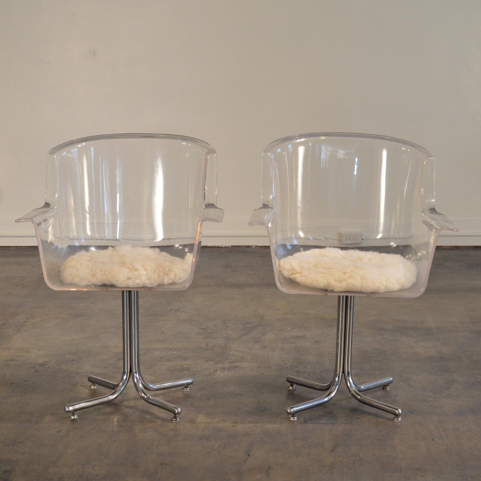 Molded Lucite swivel chairs on bases of tubular chromed steel, designed by Leon Rosen for Pace circa 1960. The deceptively simple form of the Lucite chair offers comfort and style in a multitude of settings. 

The swivel mechanisms and chromed