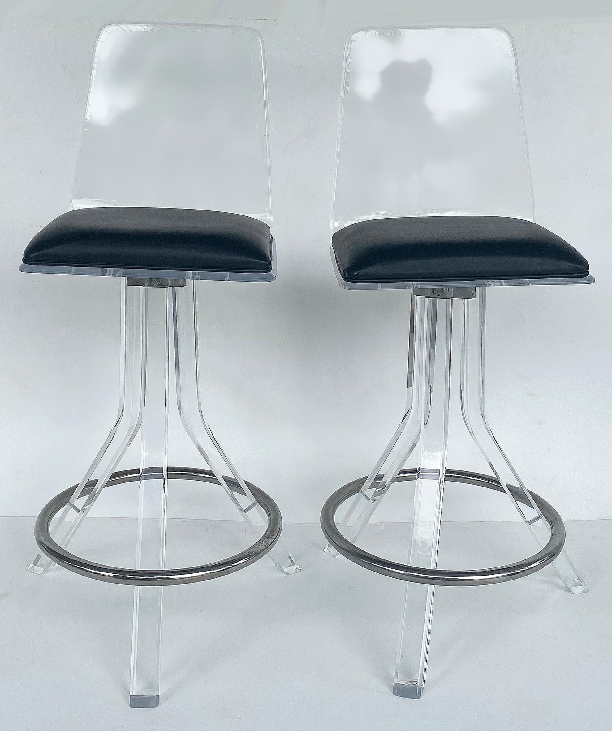 Lucite swivel bar stools attributed to Hill Manufacturing, a pair

Offered for sale is a pair of lucite swivel bar stools attributed to Hill Manufacturing Company. The molded clear lucite frames have black vinyl padded upholstered seats. Four legs