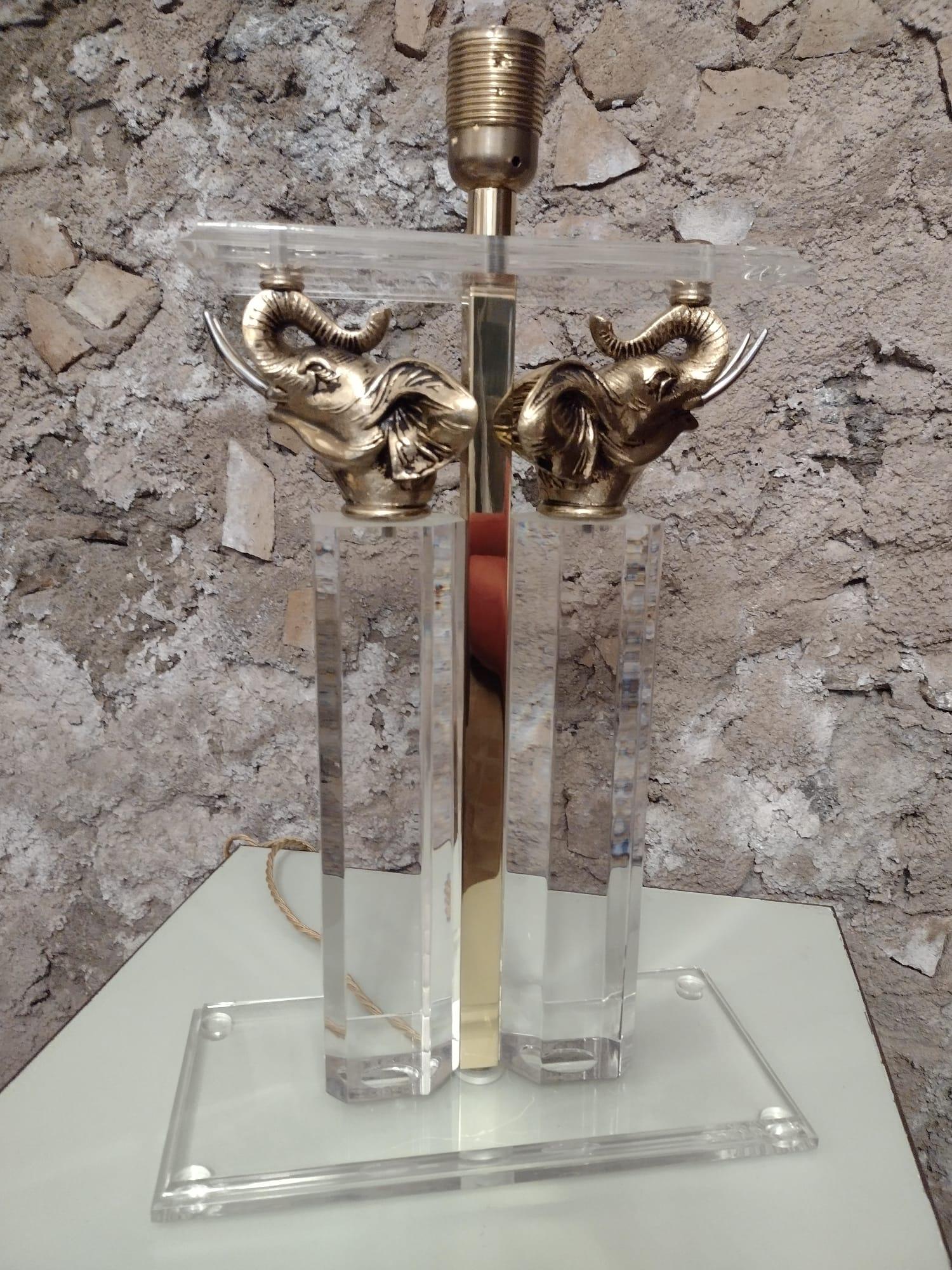 Elegant French table lamp in Lucite decorated with two bronze elephant heads.