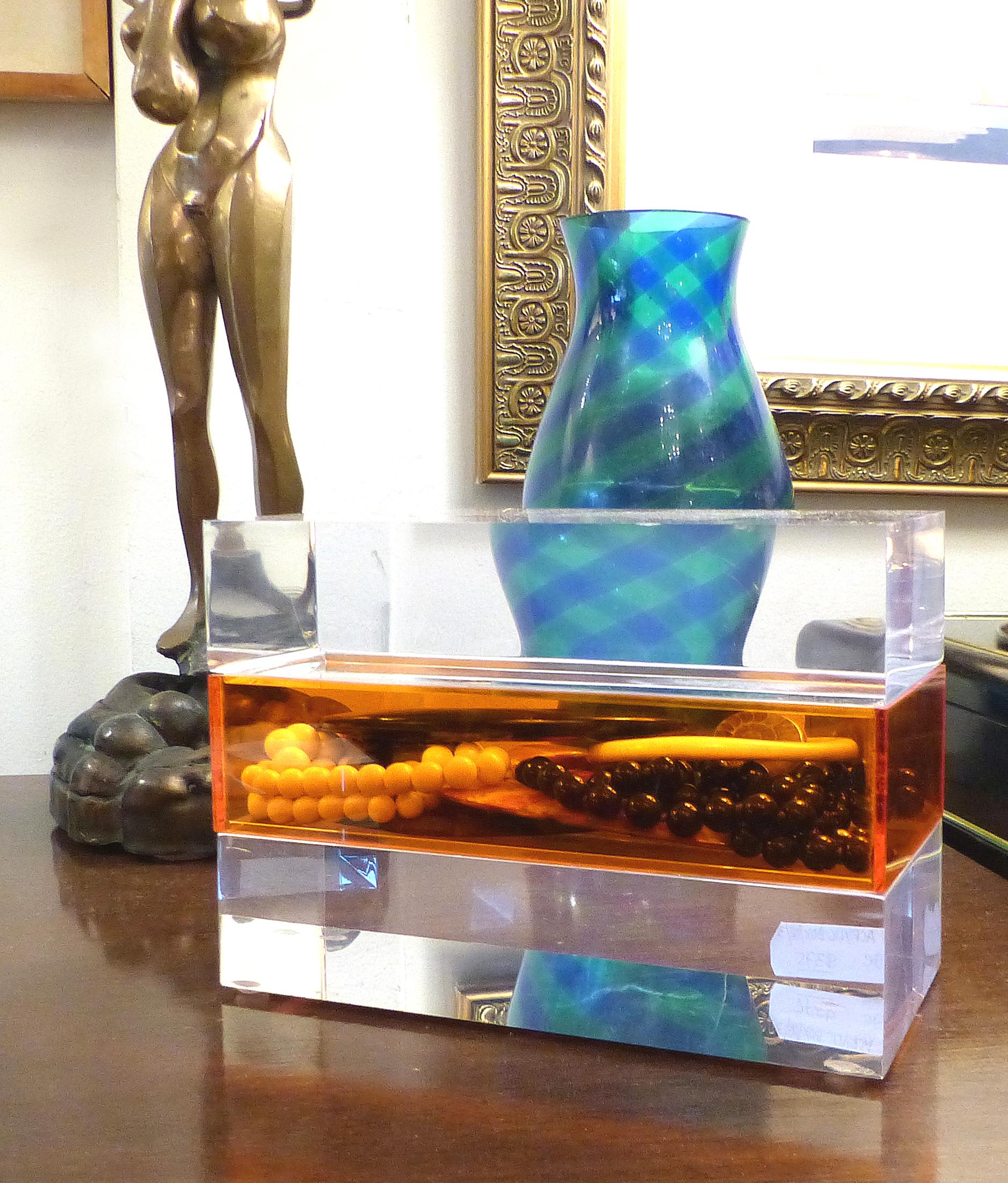 Offered for sale is a clear and orange Lucite trinket or jewelry box. The box offers a sleek storage solution with an orange compartment sandwiched between two thick slabs of Lucite. The top section is the lid which lifts off.