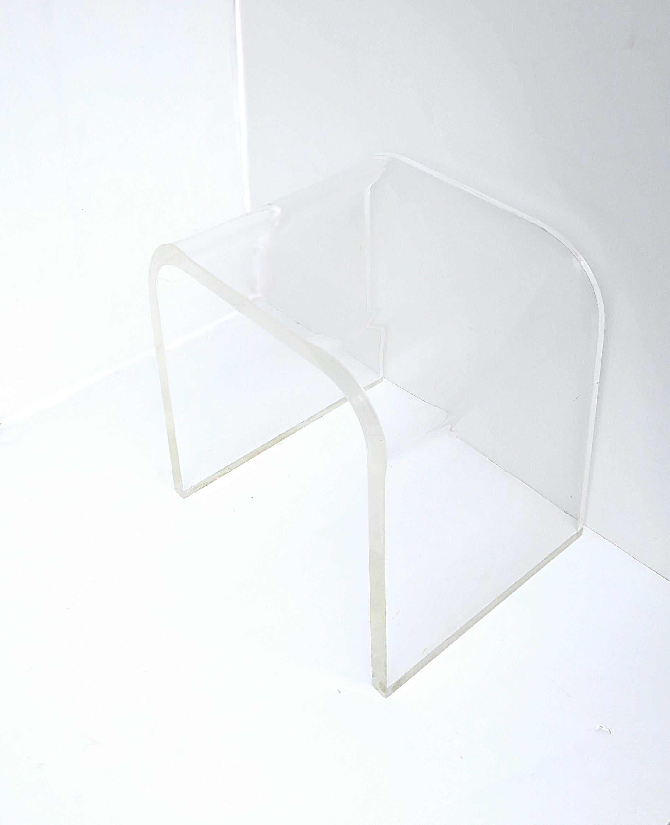 A chic and substantial Lucite bench/stool or side/end table in the Modern style/Post-Modern period, styled after designer Charles Hollis Jones, circa late-20th century. Lucite is 1