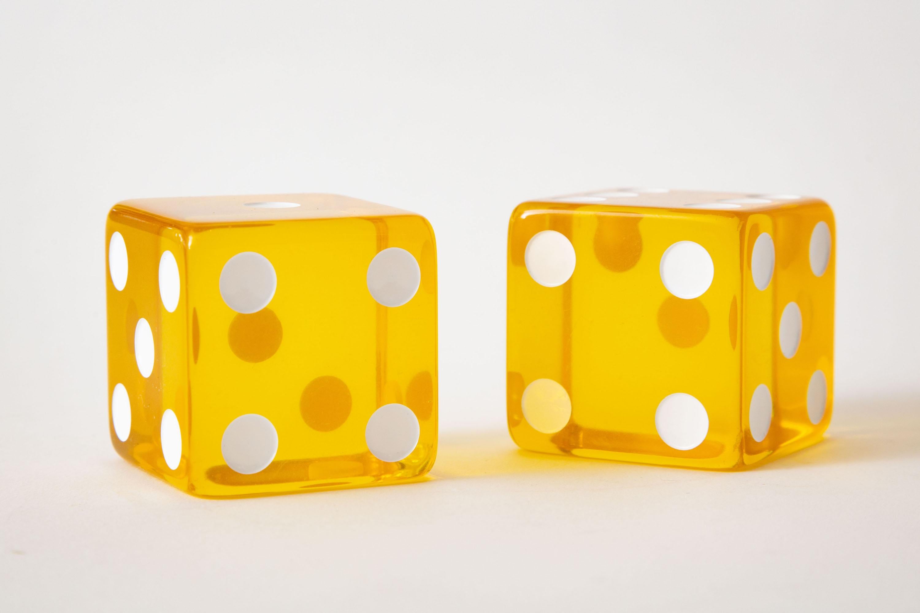 These fun and happy yellow to amber yellow and white vintage square lucite dice are from the 60's. They make a great desk accessory and or object sculpture for a cocktail table or console. Sunshine will be brought into your home. Sold as a pair.