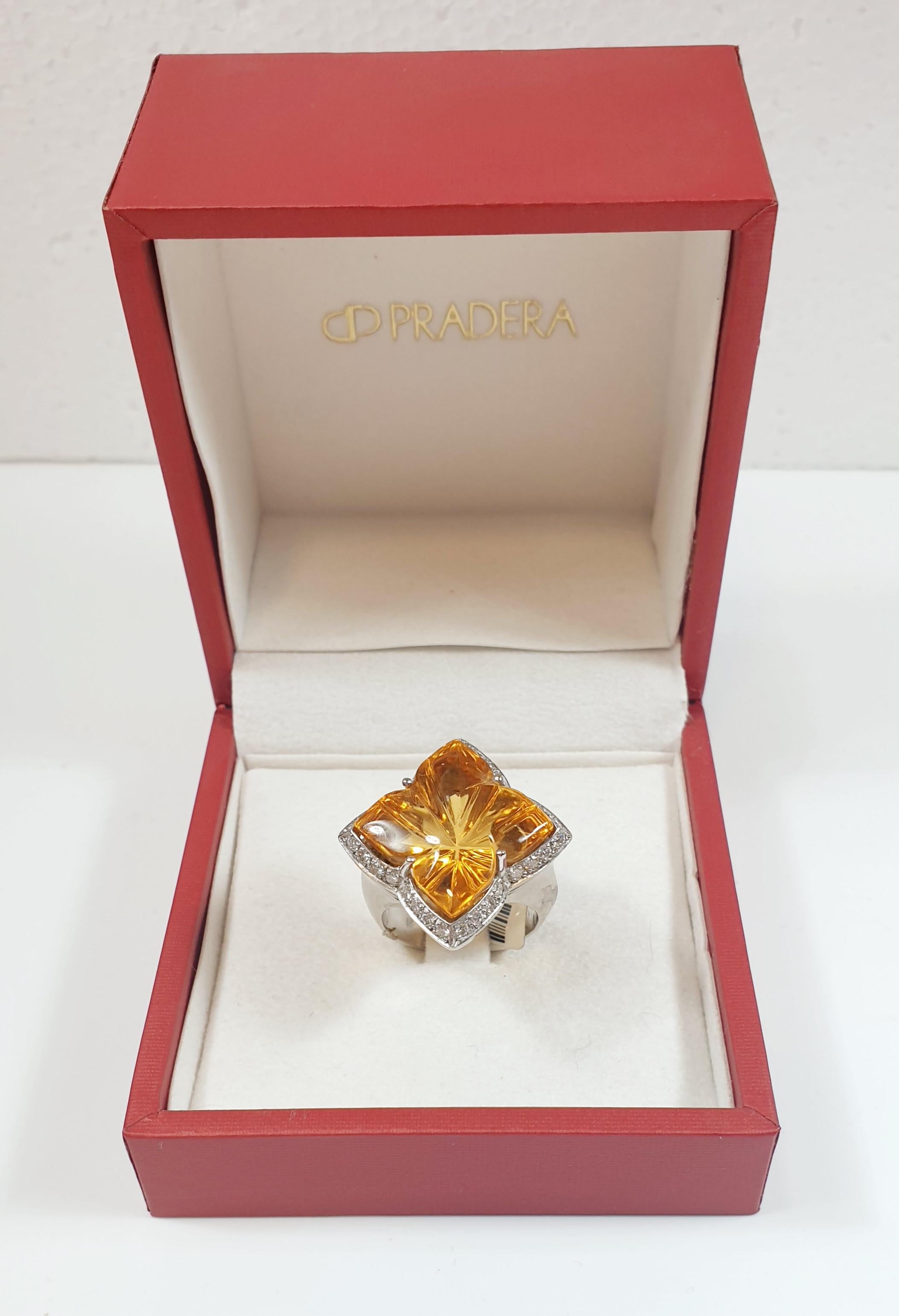Lucky Clover Ring 18K White Gold with Diamonds and central Lemmon Citrine
Ring 18K White Gold with Citrine as the Center Stone surrounded by Diamonds

White Gold 18K
Peridot 1,8 cm x1,8 cm
Weight 15,8 gr.

IRAMA PRADERA the creative director of
