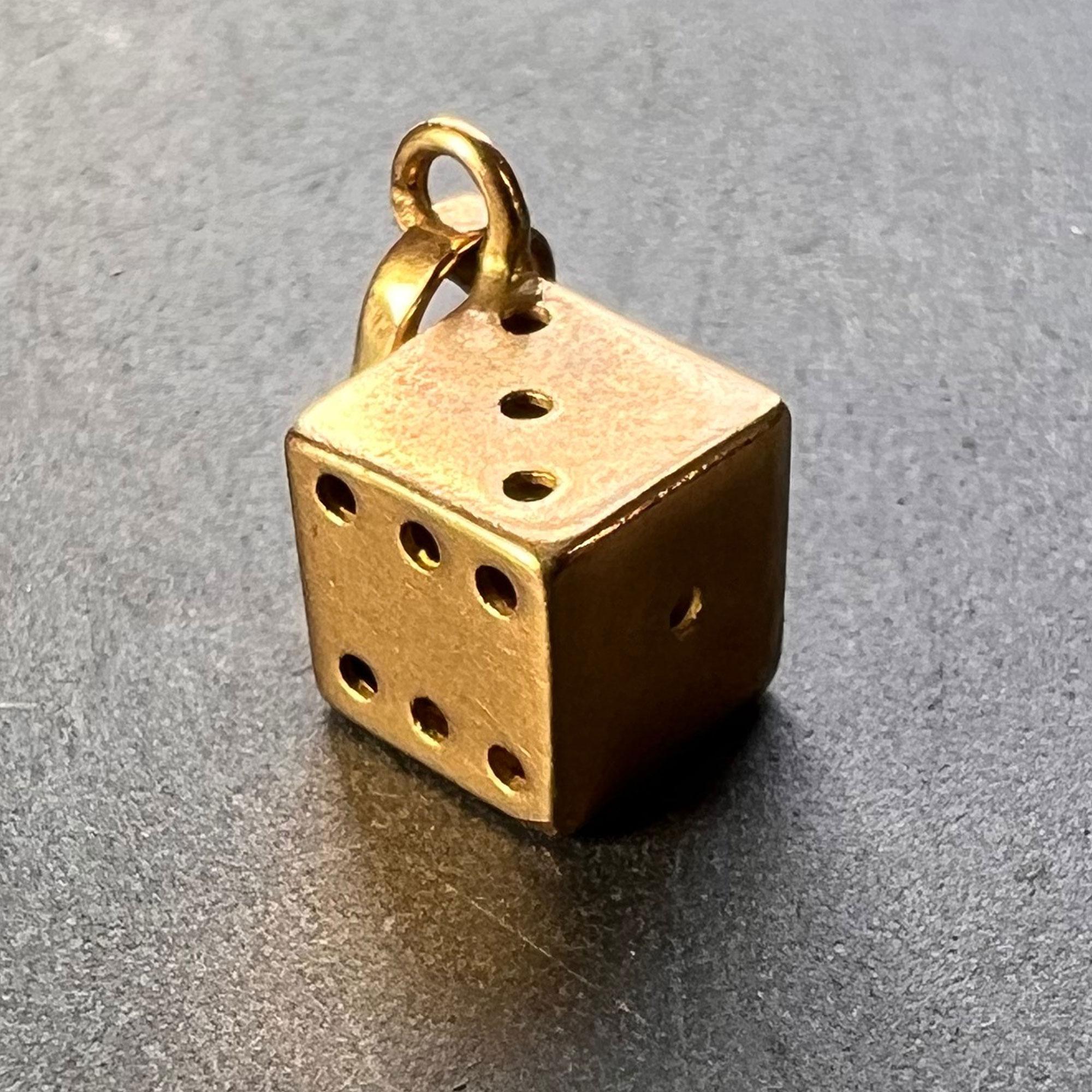 An 18 karat (18K) yellow gold charm pendant designed as a lucky dice with drilled pips. Stamped 750 for 18 karat gold with a French import mark for 18 karat gold.
 
Dimensions: 0.65 x 0.65 x 0.65 cm (not including jump ring)
Weight: 1.01