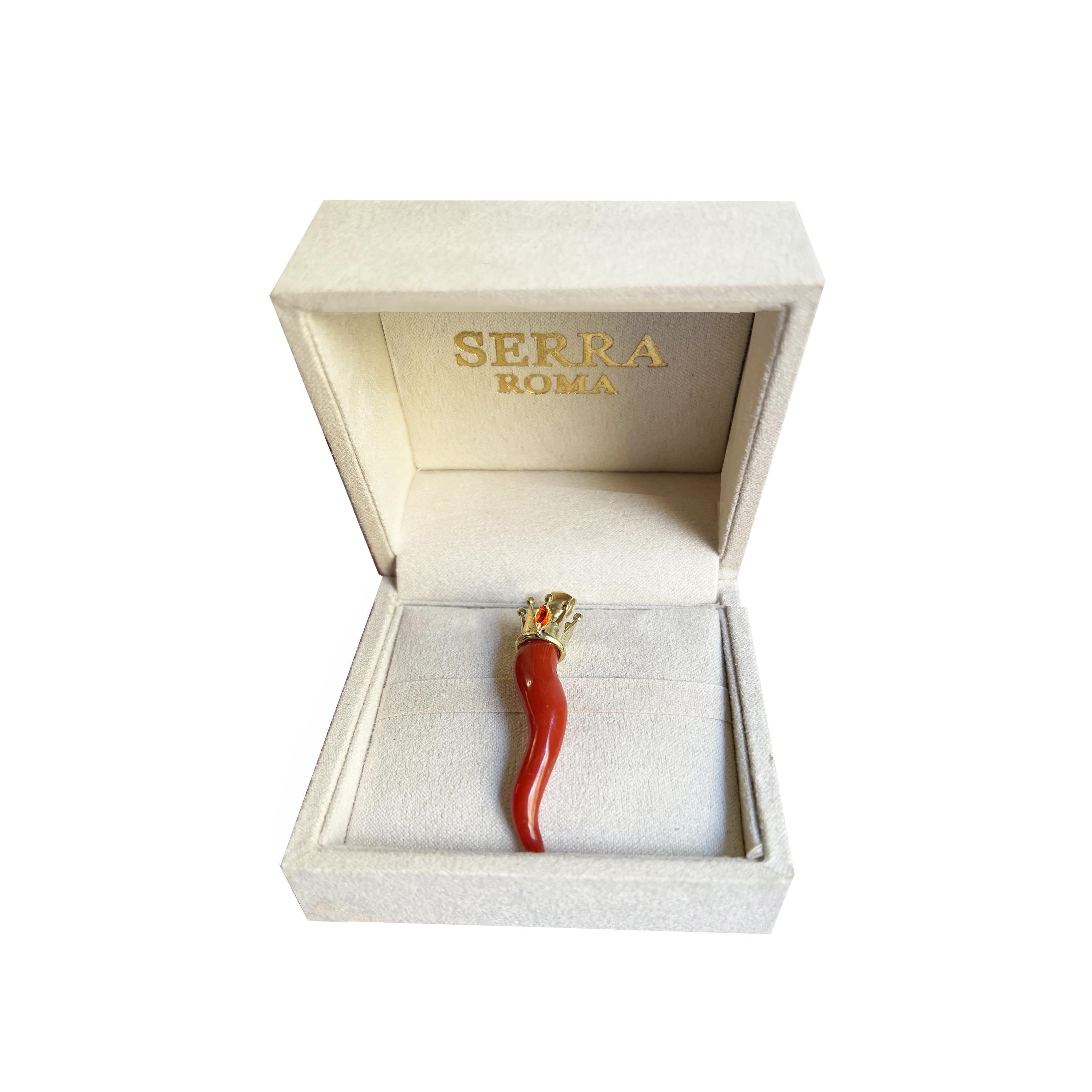 This beautiful coral and 18 Kt gold horn comes from the Italian sea and was purchased in Torre del Greco, which has a long tradition in coral jewelry, and then mounted with an 18 Kt gold crown and a small topaz by our goldsmiths. . 
The coral horn