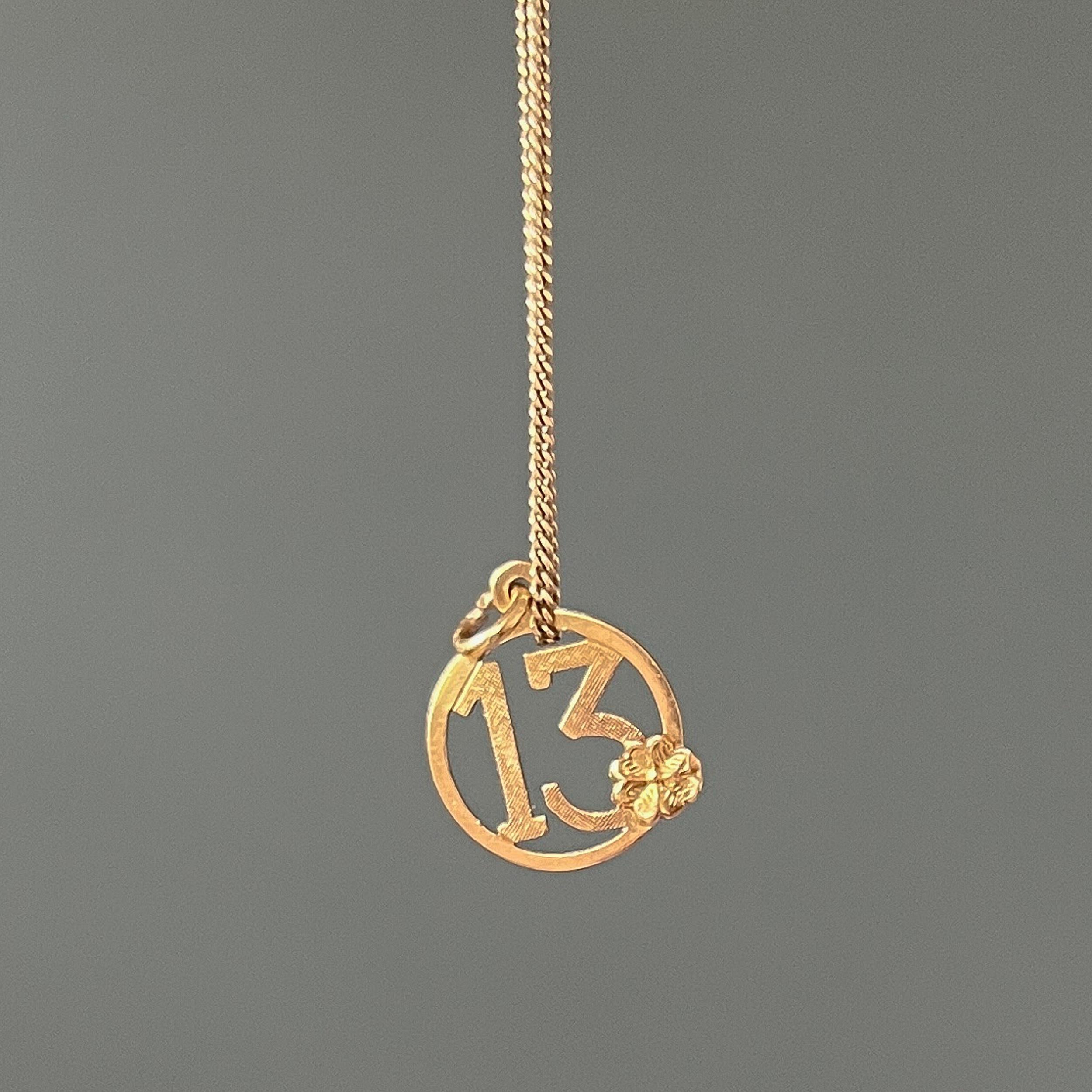 This lucky number thirteen vintage charm is made in 18 karat yellow gold. It has a lovely clover leaf on the front and the number has engraved diagonal lines. There’s nothing to fear about this number. In several cultures, this number is considered