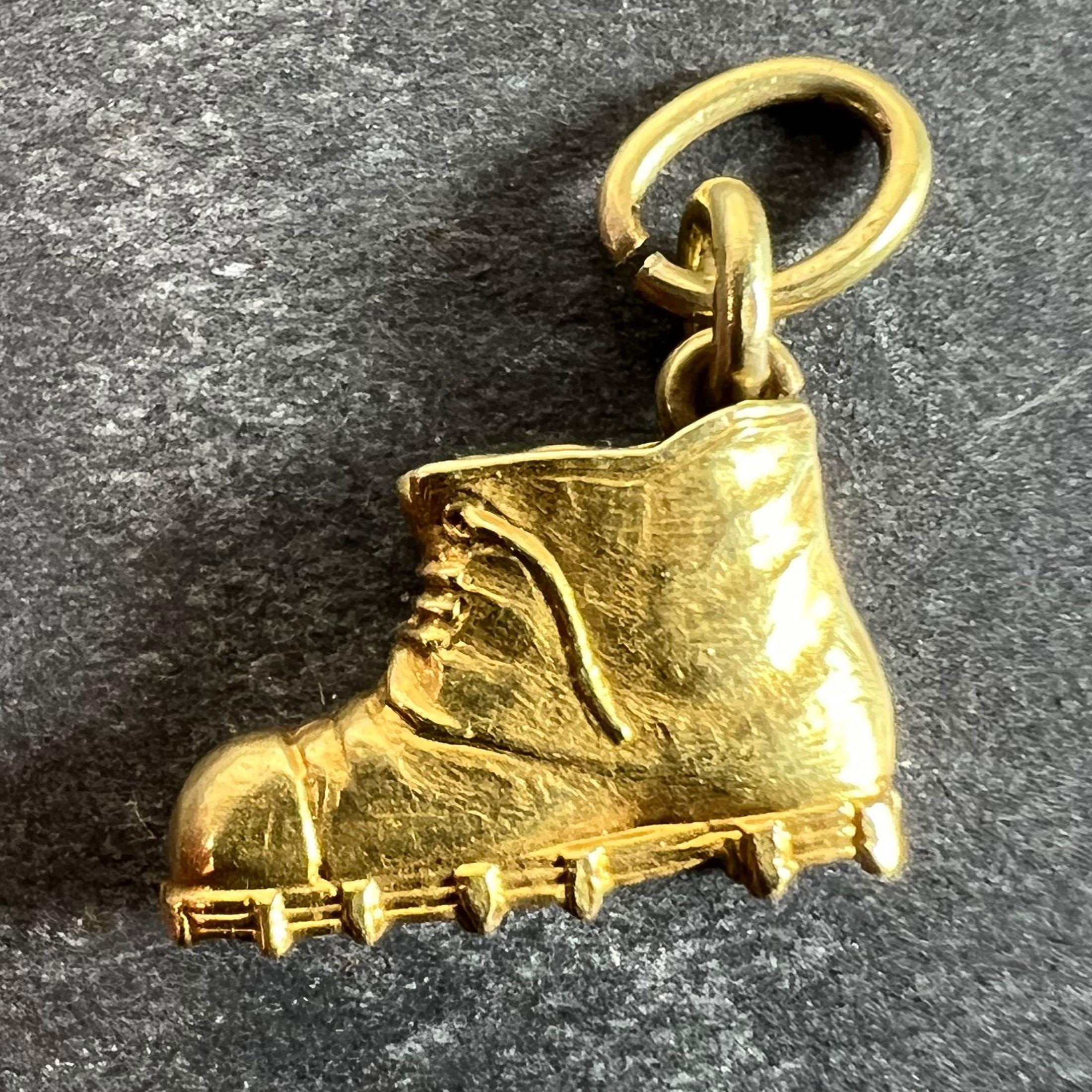Un pendentif porte-bonheur en or jaune 18 carats (18K) conçu comme une vieille botte chanceuse avec un lacet cassé. Non marqué mais testé pour l'or 18 carats.

Dimensions : 1,2 x 1,3 x 0,32 cm (sans l'anneau de saut) : 1,2 x 1,3 x 0,32 cm (sans