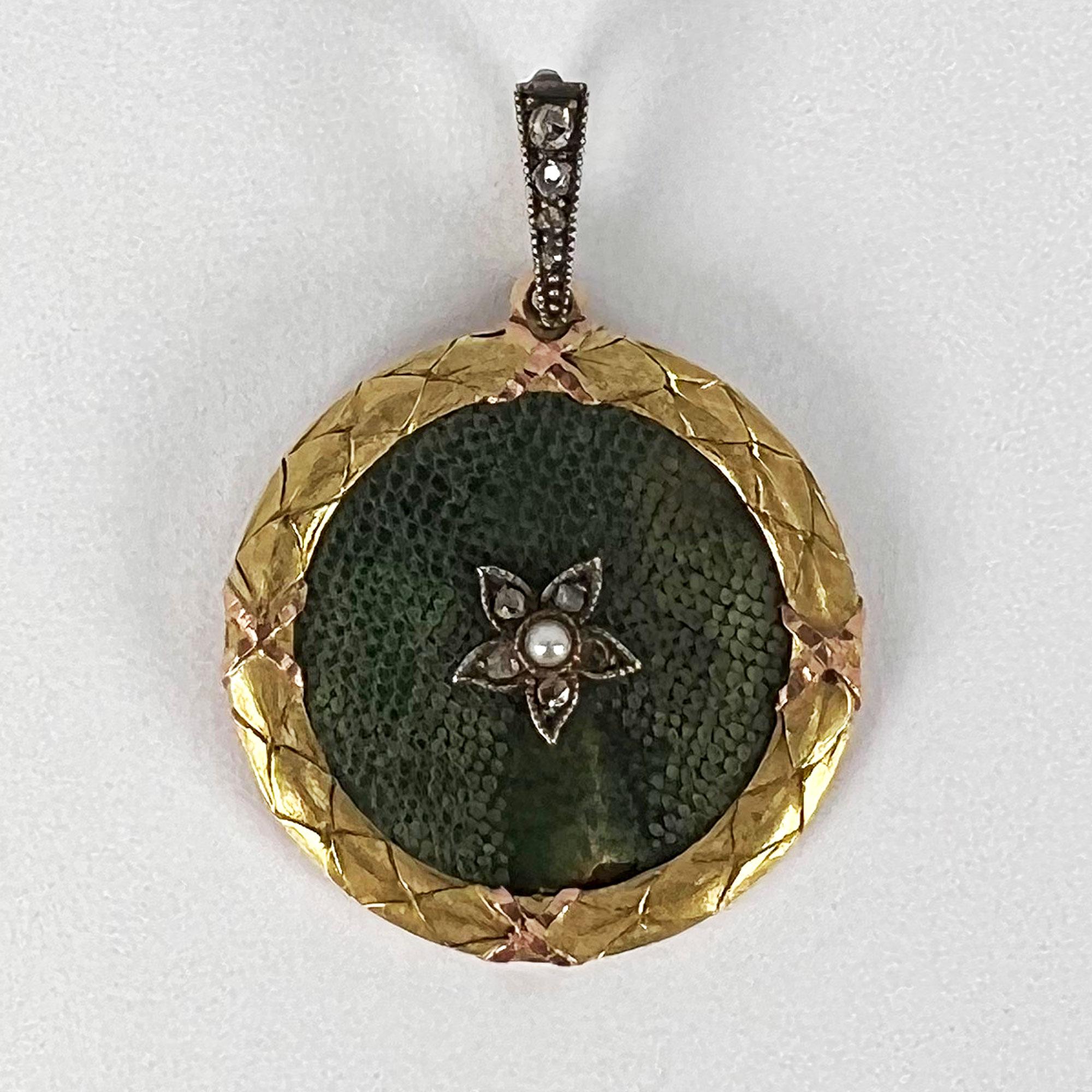An 18 karat (18K) yellow gold and charm pendant designed as a circle of green shagreen set to the centre with a pearl and diamond lucky star within a laurel wreath border to indicate the triumph of love to a diamond set bail. Signed to the reverse