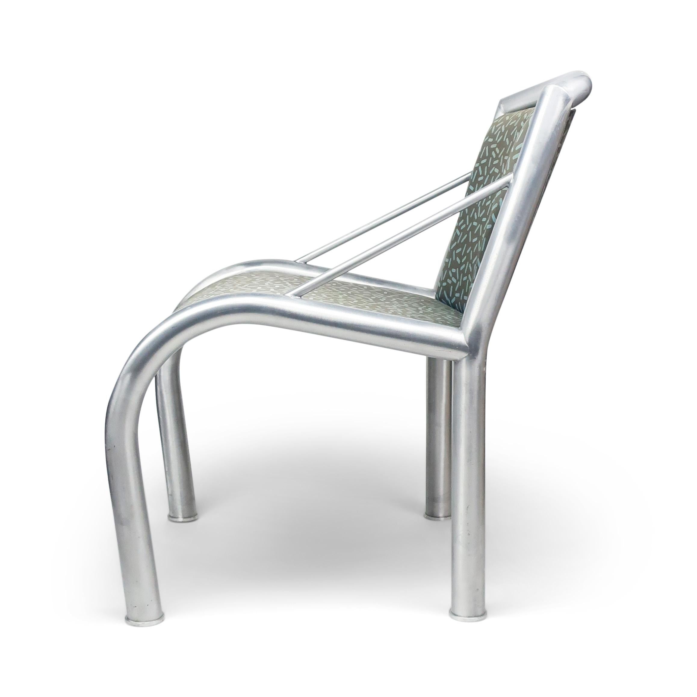 Ein Sessel aus Aluminium, entworfen von Marco Zanini für Memphis Milano im Jahr 1984 und bezogen mit Letraset, einem Baumwollstoff von Ettore Sottsass. 

Signiert auf der Unterseite des Sitzes. In gutem Vintage-Zustand mit alters- und