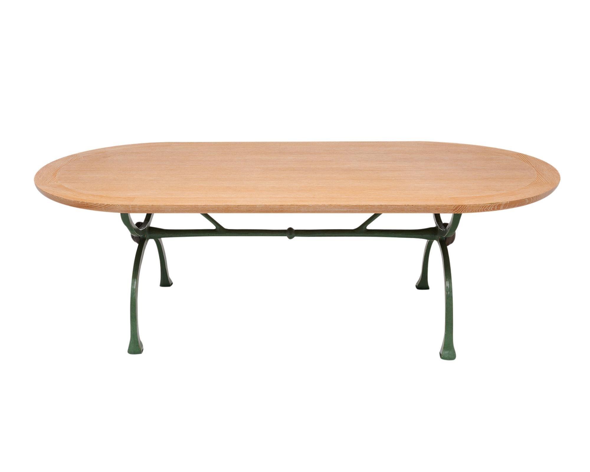 Dining table from France by designer Christian Liaigre for Nobilis. This piece has a solid ceruse thick wood slab top and green hand hammered forged iron base. It is in excellent vintage condition.
