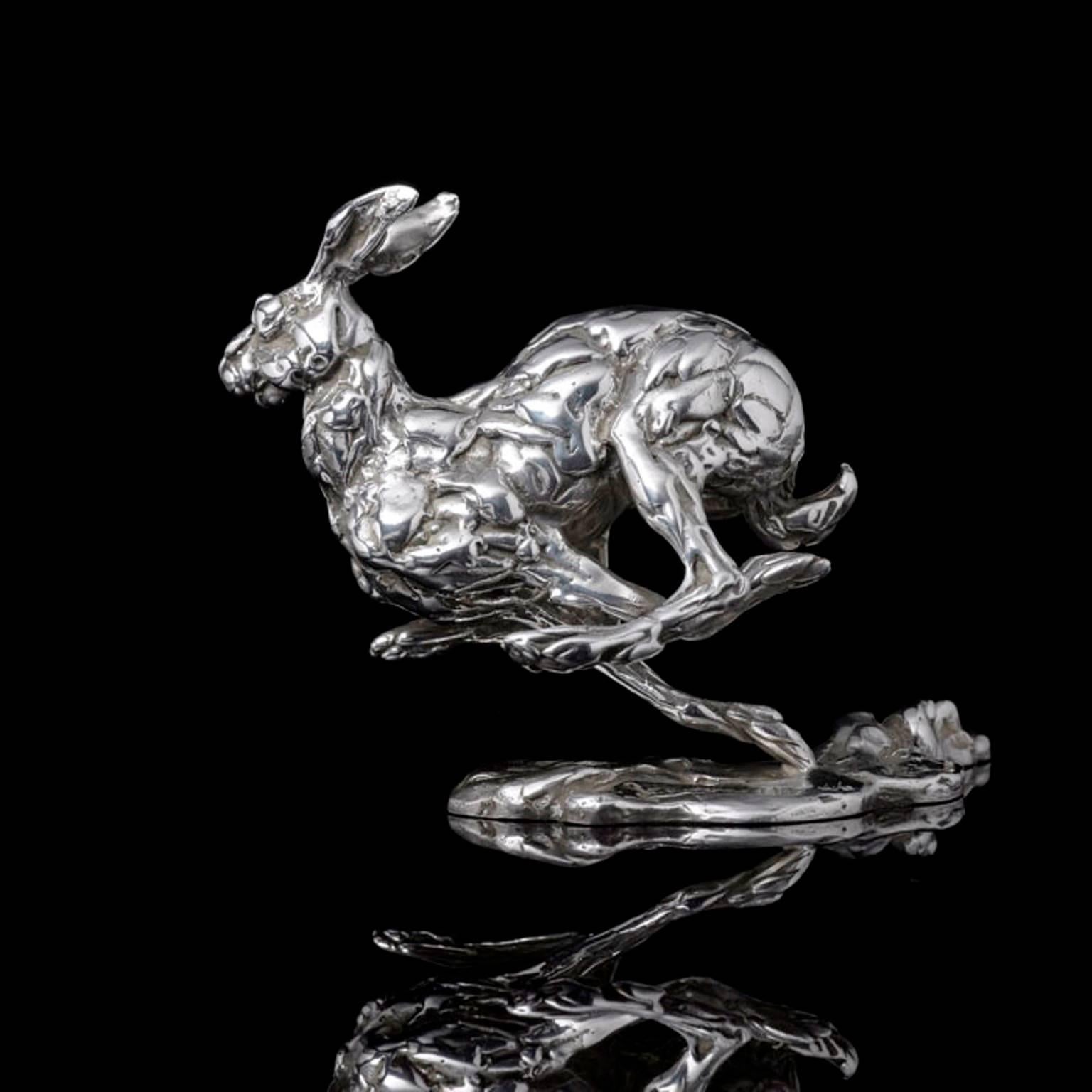 A 'Bunched Hare' sterling silver sculpture by Lucy Kinsella, the limited edition finely modelled hare caught mid stride as he races across a field.  His body bunched and hind legs reaching forward, ears blown back and nose twitching, is he chasing