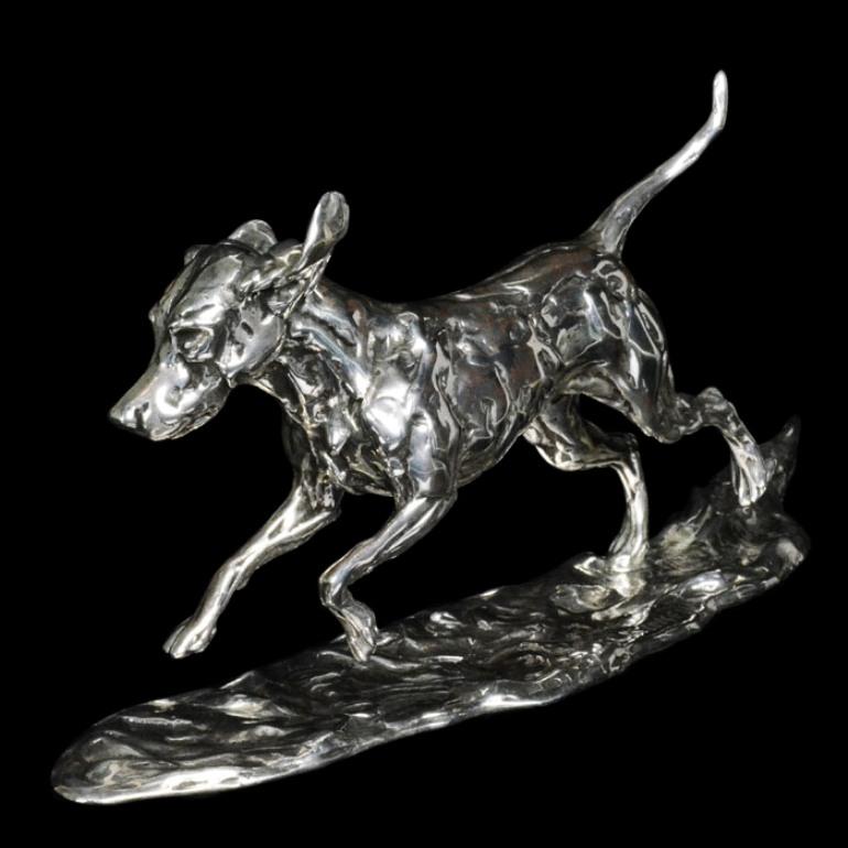 A 'Running Hound' sterling silver sculpture by Lucy Kinsella, the limited edition finely modelled hound depicted galloping across the ground with his tail flying out behind him and the wind whipping his ears around his head.  He has been sculpted in
