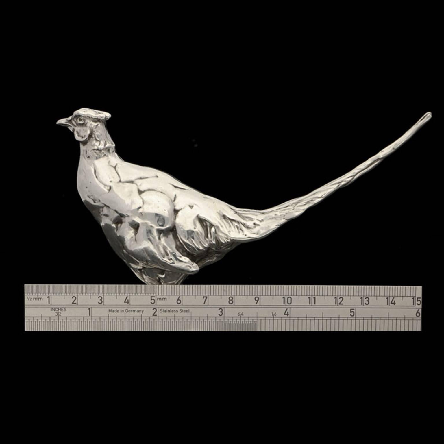 A 'Standing Pheasant' sterling silver sculpture by Lucy Kinsella, the limited edition finely modelled male Chinese ring neck pheasant stands with his tail raised, watchful and alert, his beady eyes warily observing his surroundings.  He has been