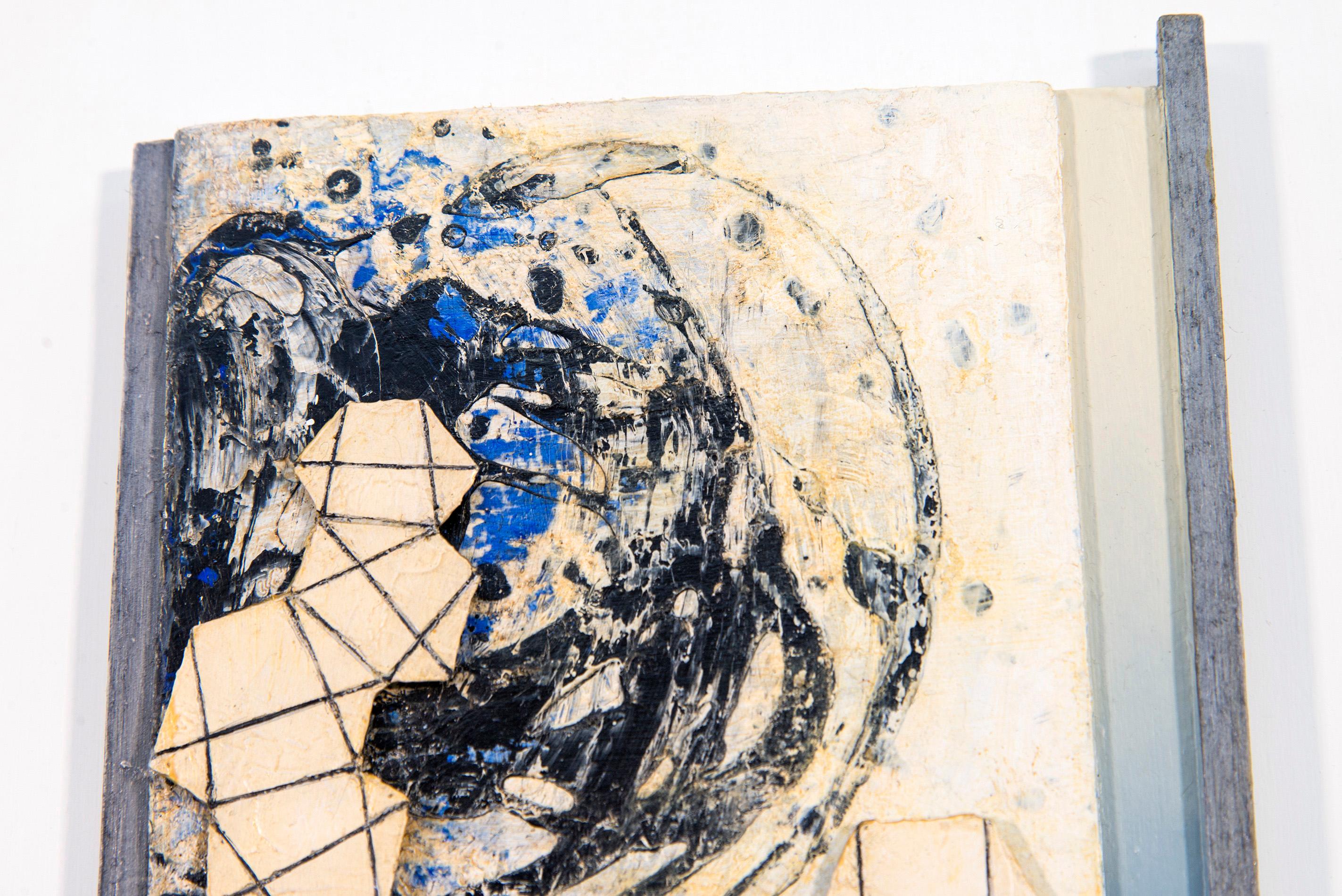 Questa intrigante composizione astratta a tecnica mista è opera di Lucy Maki. Due pannelli di colore bianco, nero, giallo pallido e blu intenso si trovano uno sopra l'altro: ogni pannello presenta una forma simile a un globo e forme geometriche