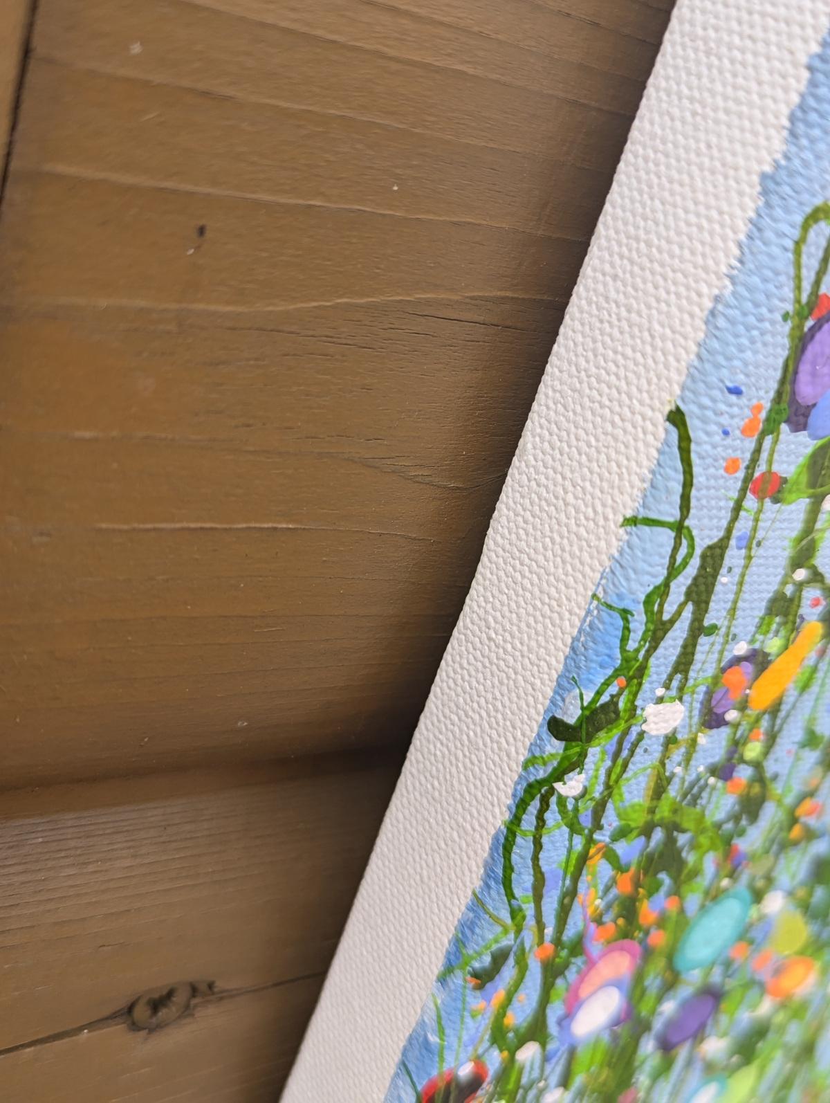 A Symphony Of Colour #2 Dieses Gemälde ist eine lebhafte Feier der Spontaneität und Schönheit der Natur, dargestellt durch energische Farbspritzer und dynamische, abstrakte Formen, die das Wesen einer blühenden Wiese unter einem klaren blauen Himmel
