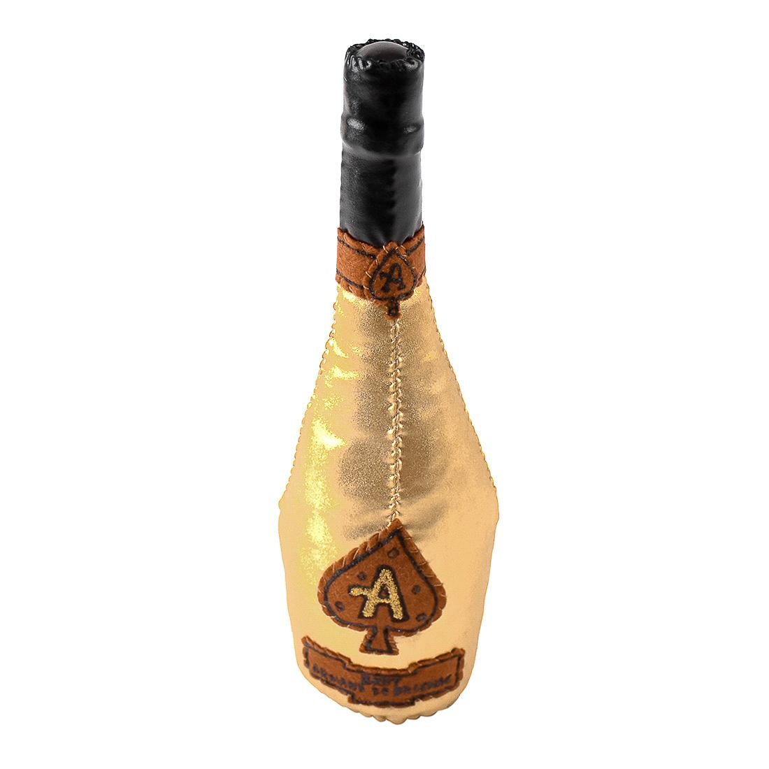 Sculpture is based on the Ace Of Spades Champagne bottle.
Hand made multiple by artist.
Hand signed with black ink by Lucy Sparrow on back of sculpture.
Label on bottle reads “Armand De Brignac”.
Gold fabric with brown and black felt.
Certificate of