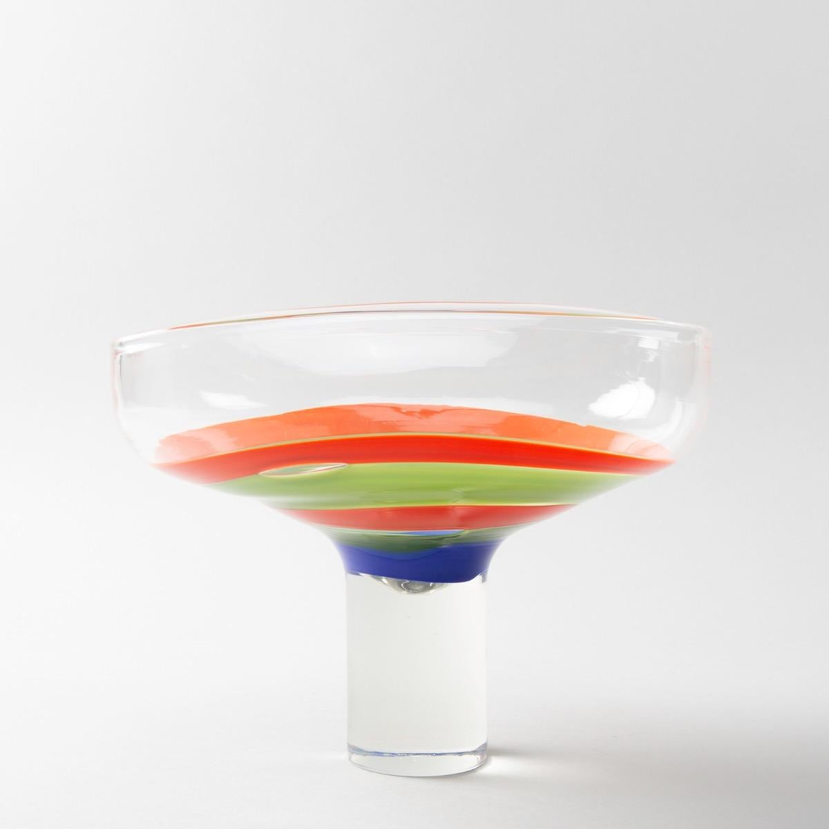 A rare large cup designed for Philips, circa 1968-1970 by Ludovico Diaz de Santillana.
A rectangular cup on a cylindrical high foot.
The centre decorated with concentric bands of orange, blue and green glass.
This designed ordered by the company