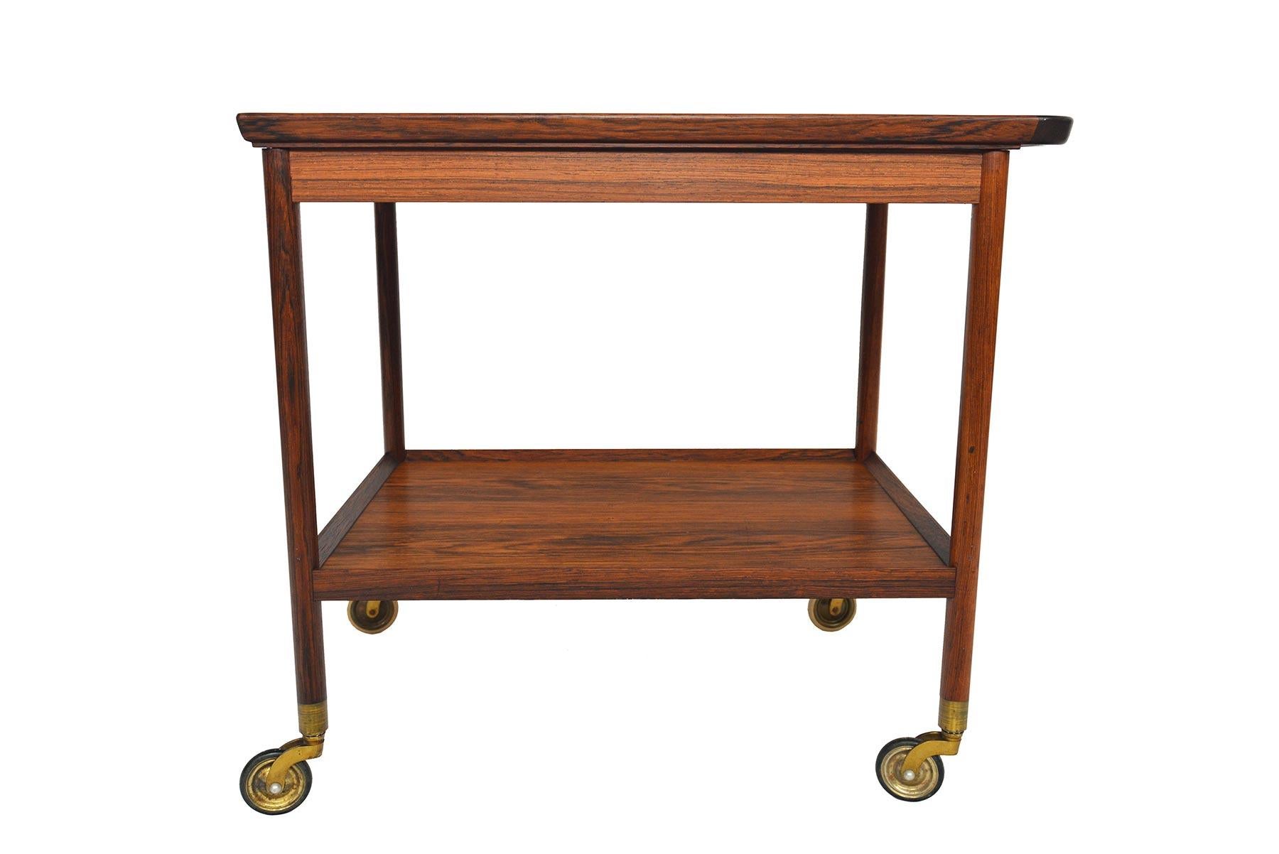 This Danish midcentury bar cart by Ludvig Pontoppidan in Brazilian rosewood is ideal for modern entertaining! The two tier design offers a black laminate serving top, a lower level for storage, and a seamless handle for convenient mobility. Cart