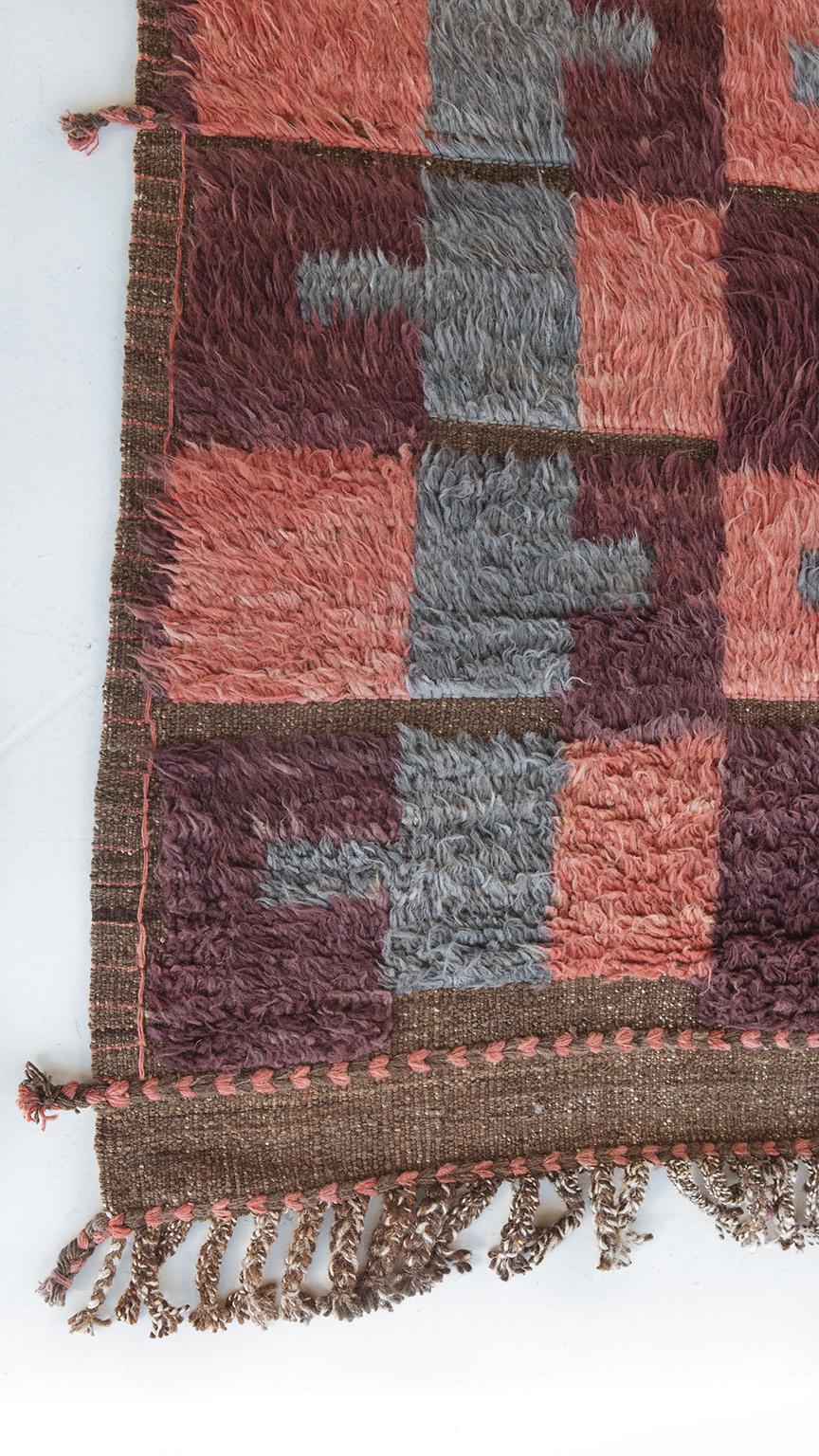 Handwoven shag rug creating an all-over repeating pattern incorporating a blue-grey, pink and a burgundy purple. Inspired by Scandinavian design elements and recreated for the modern design world. Crafted with care, withstanding high amount of foot