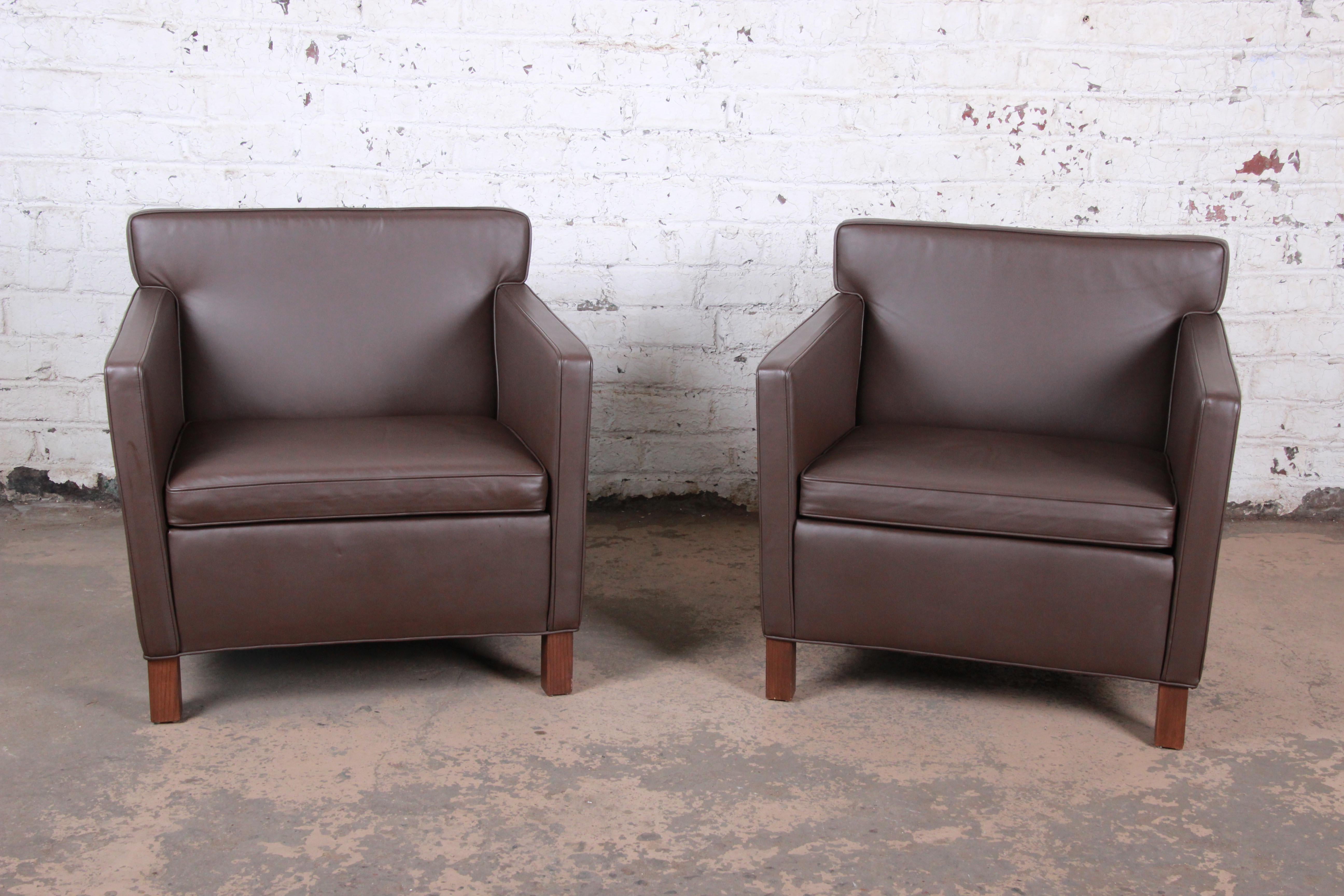 An exceptional pair of brown leather lounge chairs designed in 1927 by Ludwig Mies van der Rohe and produced by Knoll Studio. The chairs feature high-end leather upholstery with solid walnut legs and a sleek modern design. These recent production