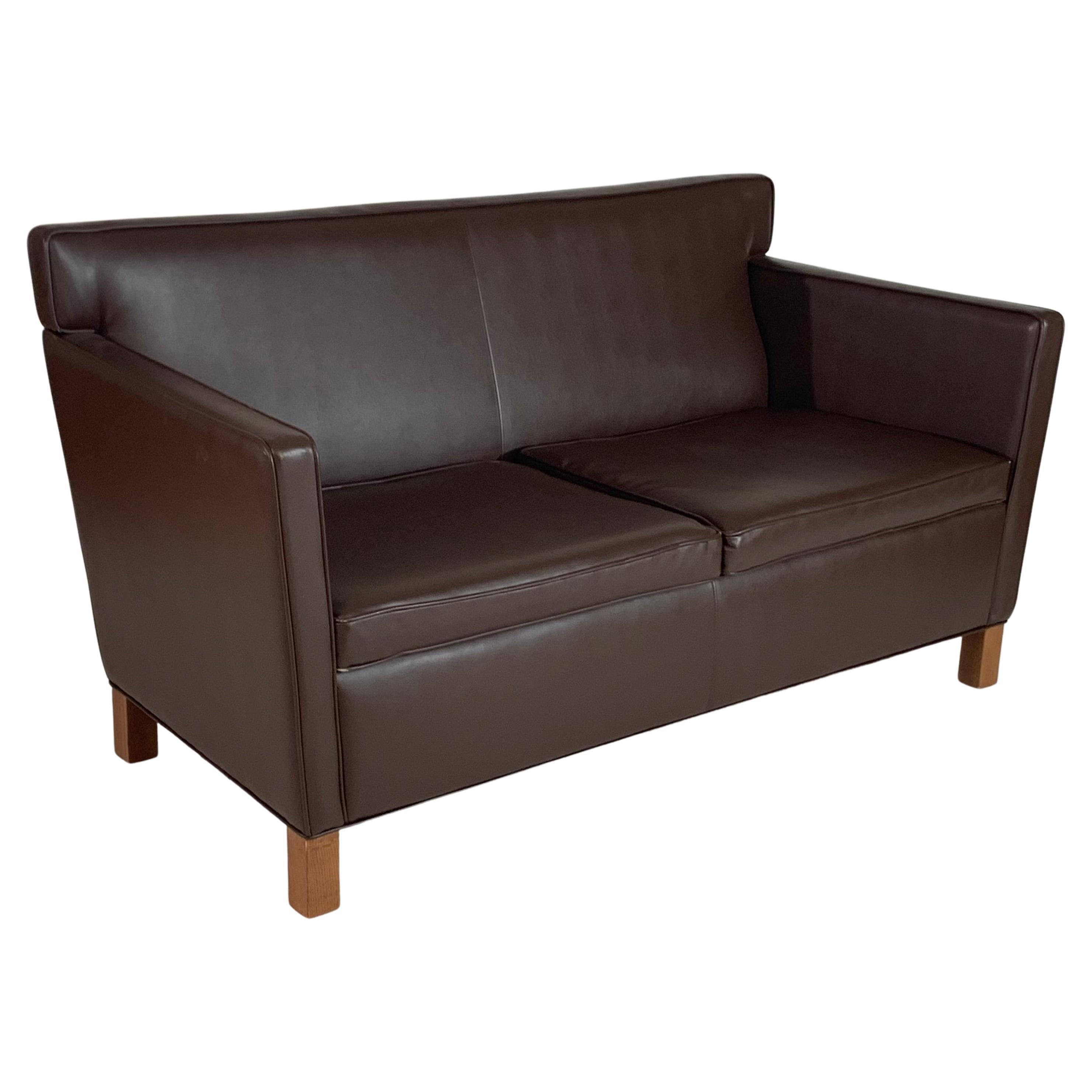 Architect Ludwig Mies van der Rohe designed Krefeld settee in a rich dark brown leather for Knoll. Recent 2009 production based on his 1930s designs for the Esters and Lange residences in Krefeld, Germany. Measures: Arm: H 25 and seat is 17