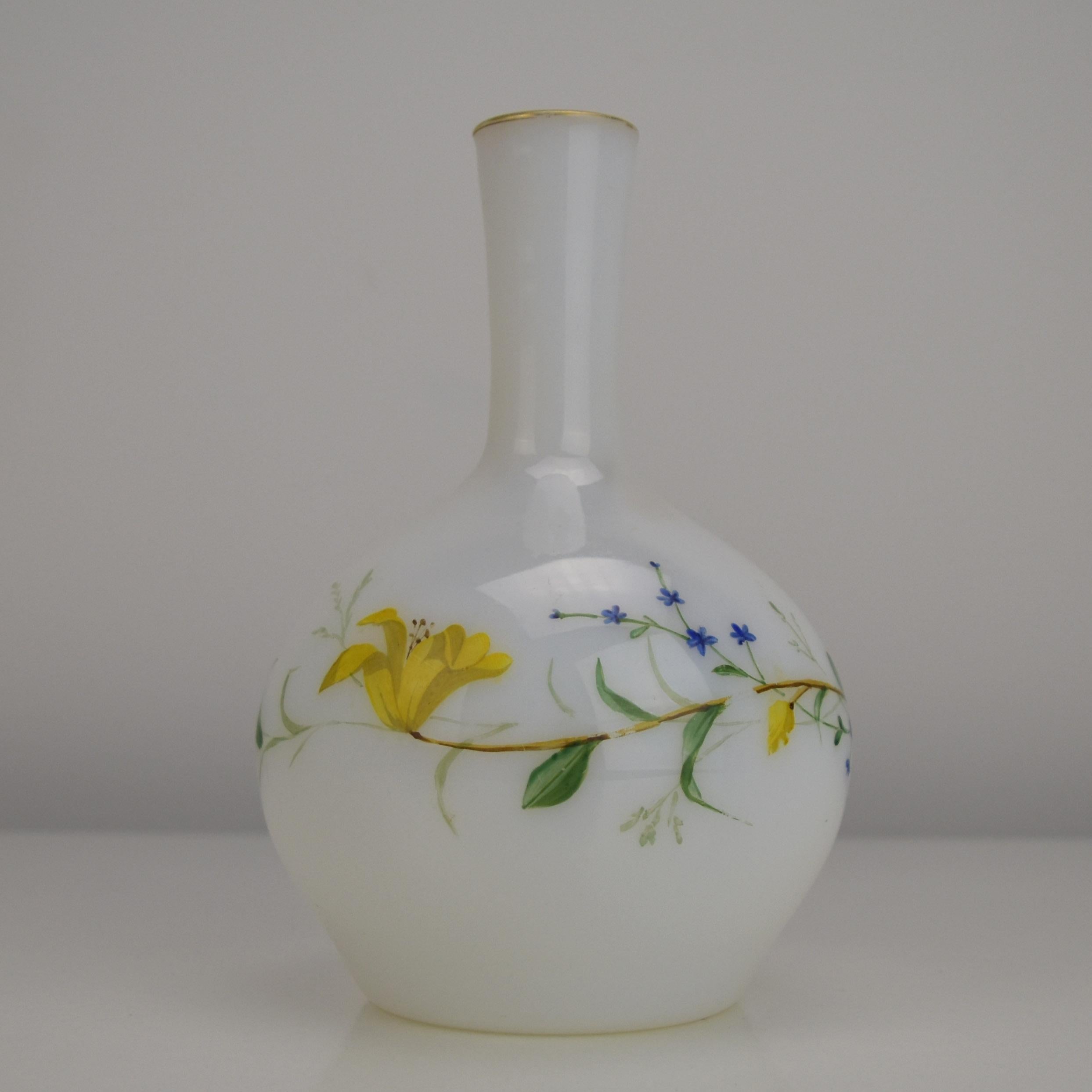 Cet exquis vase en verre opalin de Ludwig Moser, fabriqué à Karlsbad au milieu du XIXe siècle, est un exemple remarquable de l'art du verre de Bohême. L'élégant corps en opaline blanche présente un délicat motif floral peint à la main avec des
