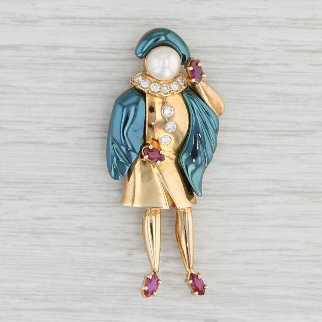 This entertaining brooch is a figural piece representing a character of the early theater troupe La Commedia dell'arte. This statement pin is a collectible Ludwig Muller piece adorned with a pearl face, rubies and diamonds as well as a blue tinting