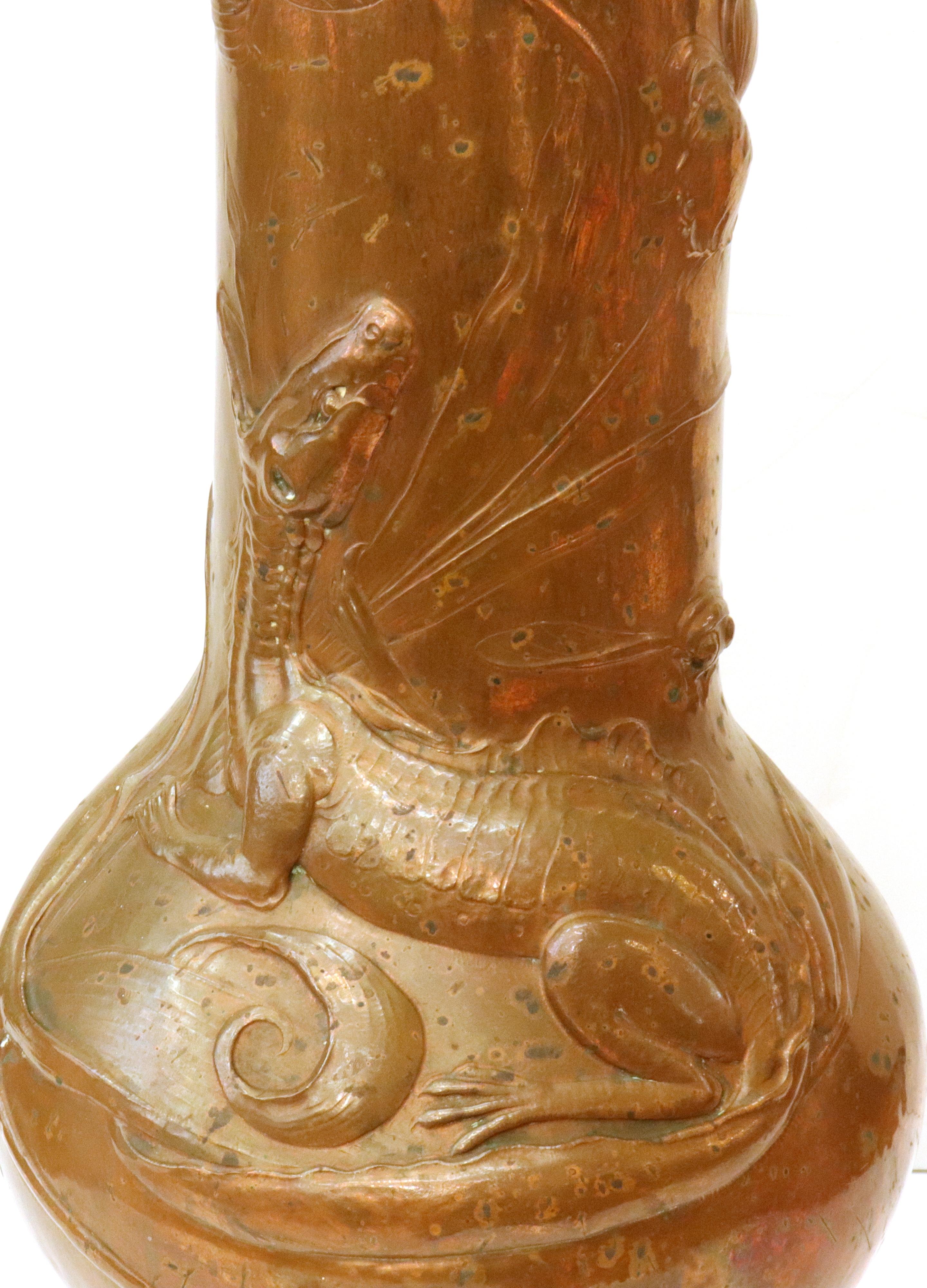 Vase monumental allemand Jugendstil conçu par Ludwig Karl Maria Vierthaler et réalisé en cuivre repoussé avec un bord en laiton. La pièce comporte un grand lézard sur le devant ainsi qu'une libellule et quelques éléments floraux. Fabriquée en