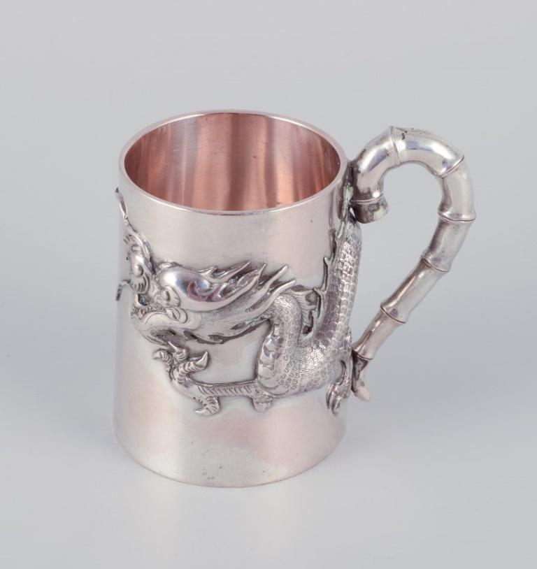 Luen-Wo, Shanghai. Silver cup with handle. Relief dragon motif.
 Handle resembling bamboo.
Approximately from the 1930s.
In excellent condition.
Hallmarked.
Dimensions: Height 7.5 cm x Diameter 7.3 cm including handle.
