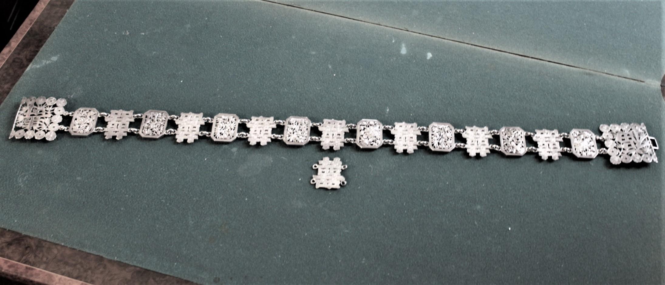 This antique sterling silver ladies belt was made by Luen Wo of Shanghai China in circa 1900 in the period Chinese Export style. The belt is done with individual block links incorporating Chinese characters with floral and leaf decoration. The links